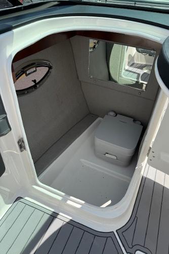 2023 Chaparral 267 SSX boat interior with compact cabin and portable toilet.
