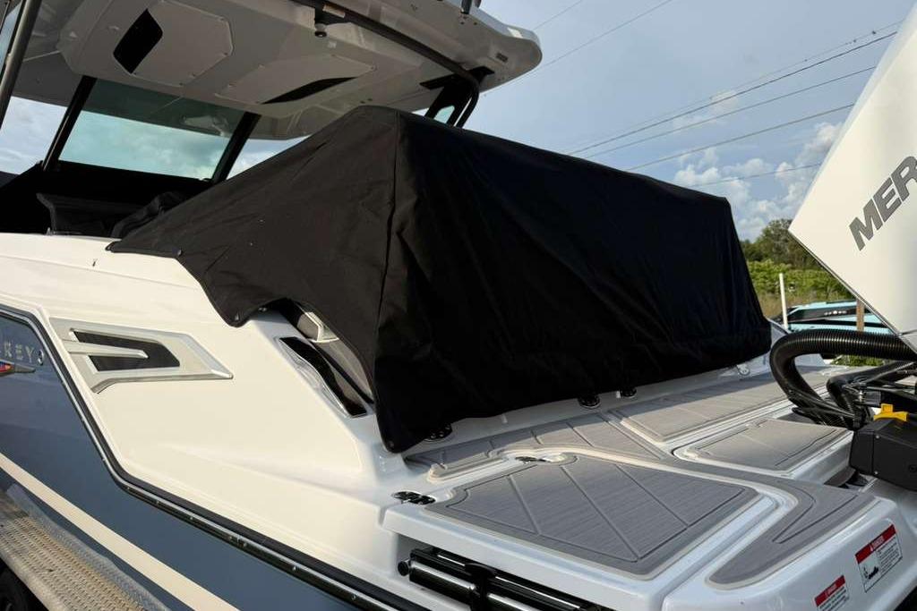 2026 Monterey Elite 30 OB boat with covered seating area and visible outboard motor.