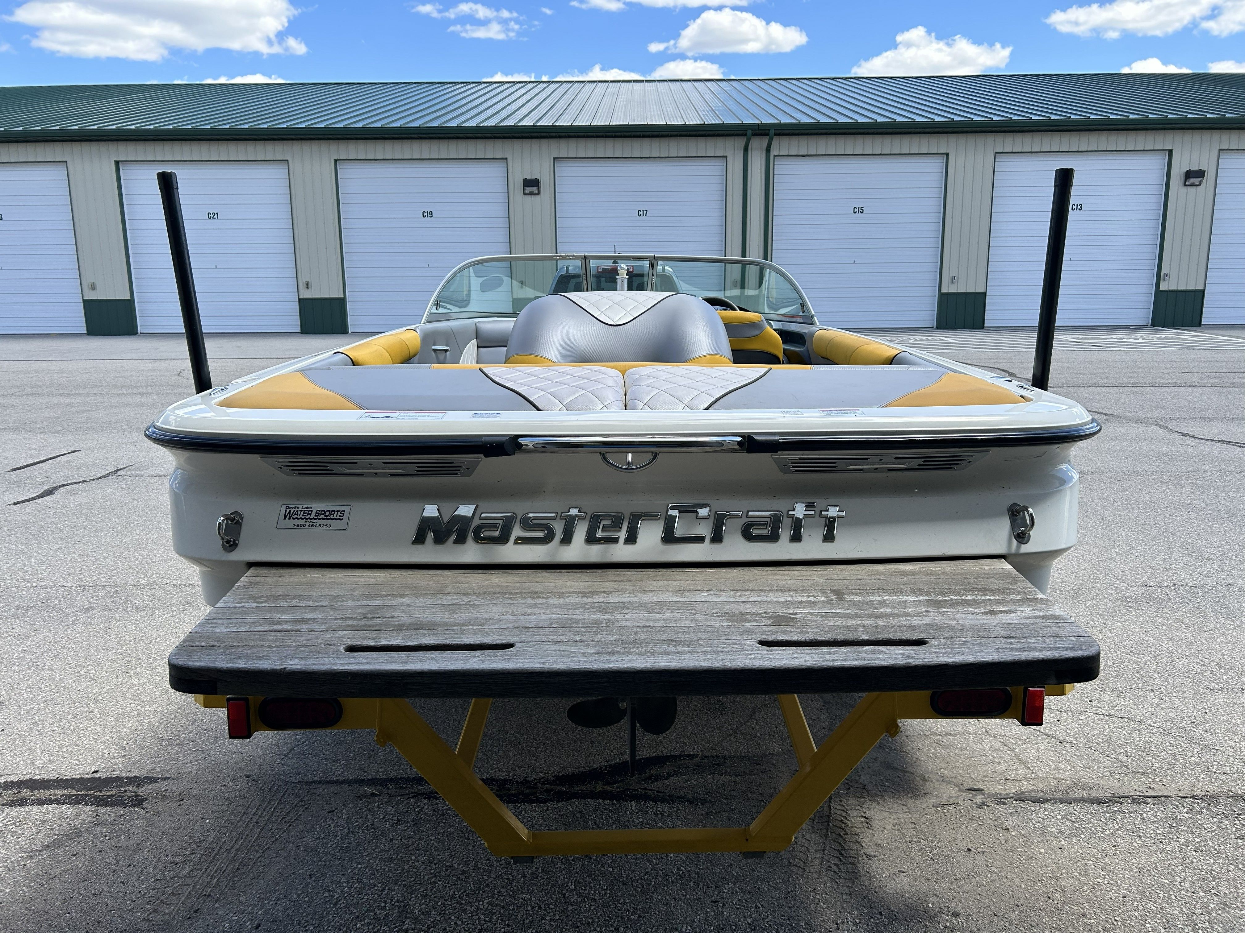 Rear view of a 2011 MasterCraft PS197 boat in front of garages.