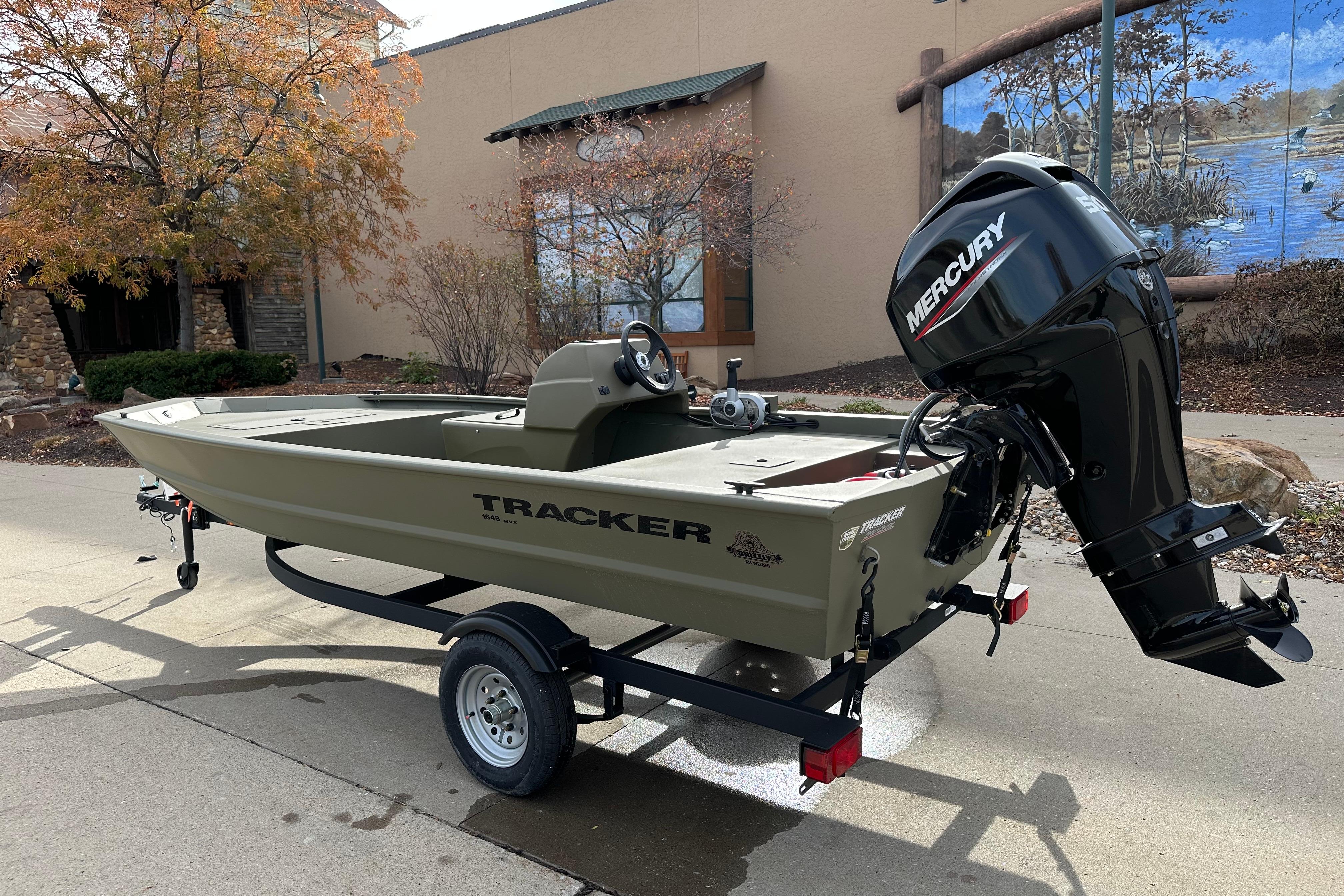 2026 Tracker Grizzly 1648 SC boat with Mercury engine on trailer, outdoors.