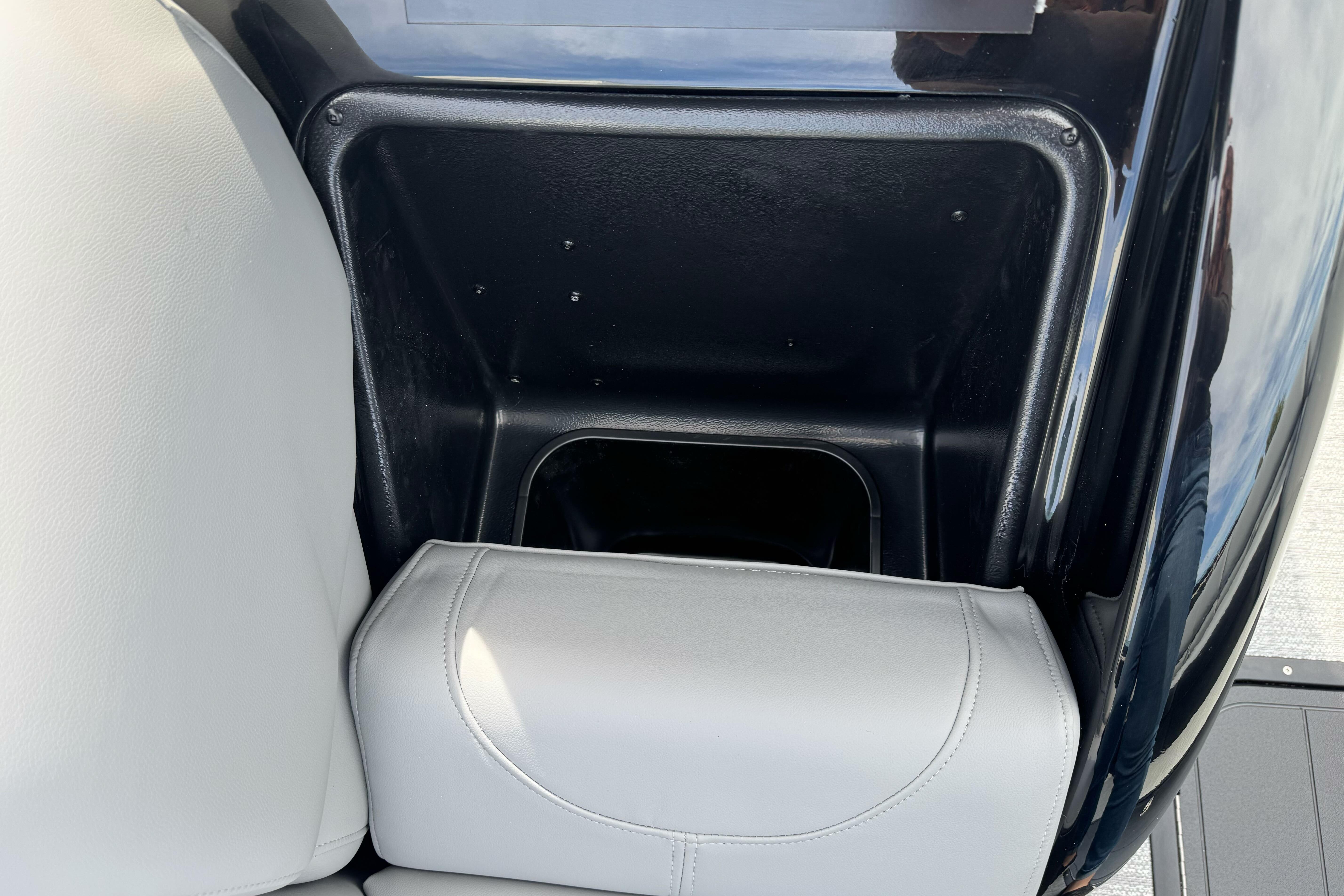 Storage compartment in 2026 Regency 250 DL boat with white cushioned seating.