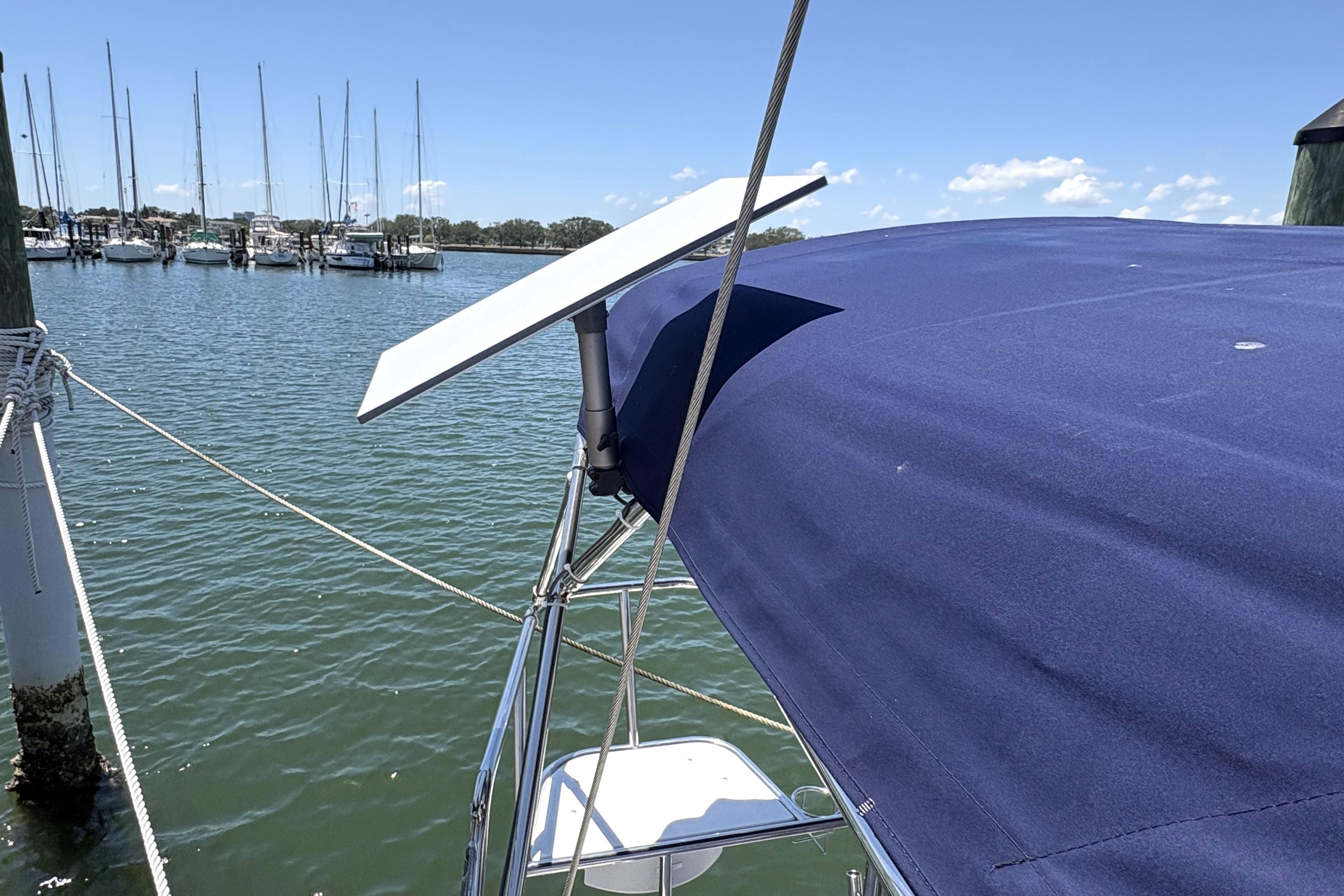 Catalina 355 sailboat with solar panel, docked in marina, clear blue sky.