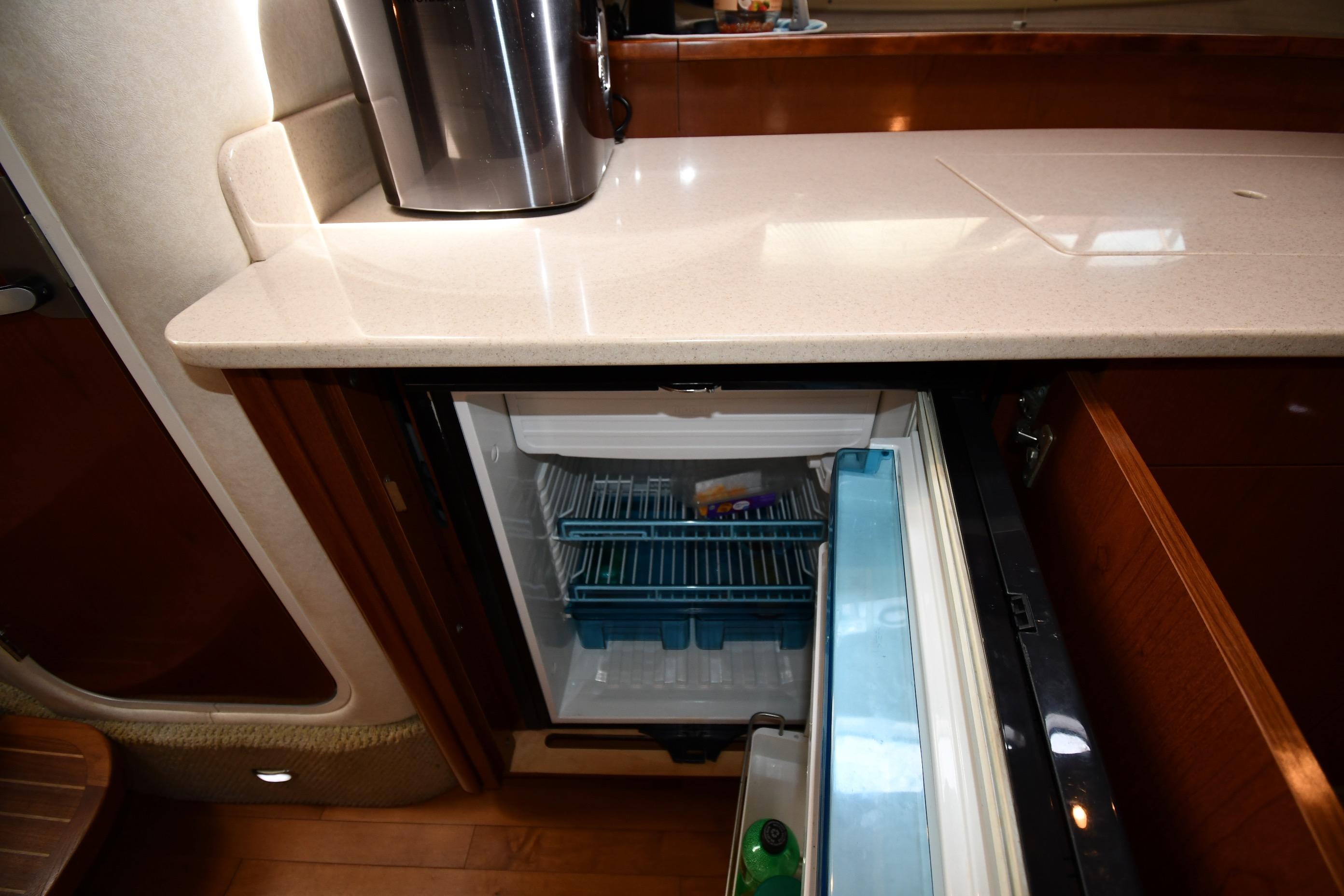 Interior of 2008 Sea Ray Sundancer 350 showing open mini fridge and countertop.