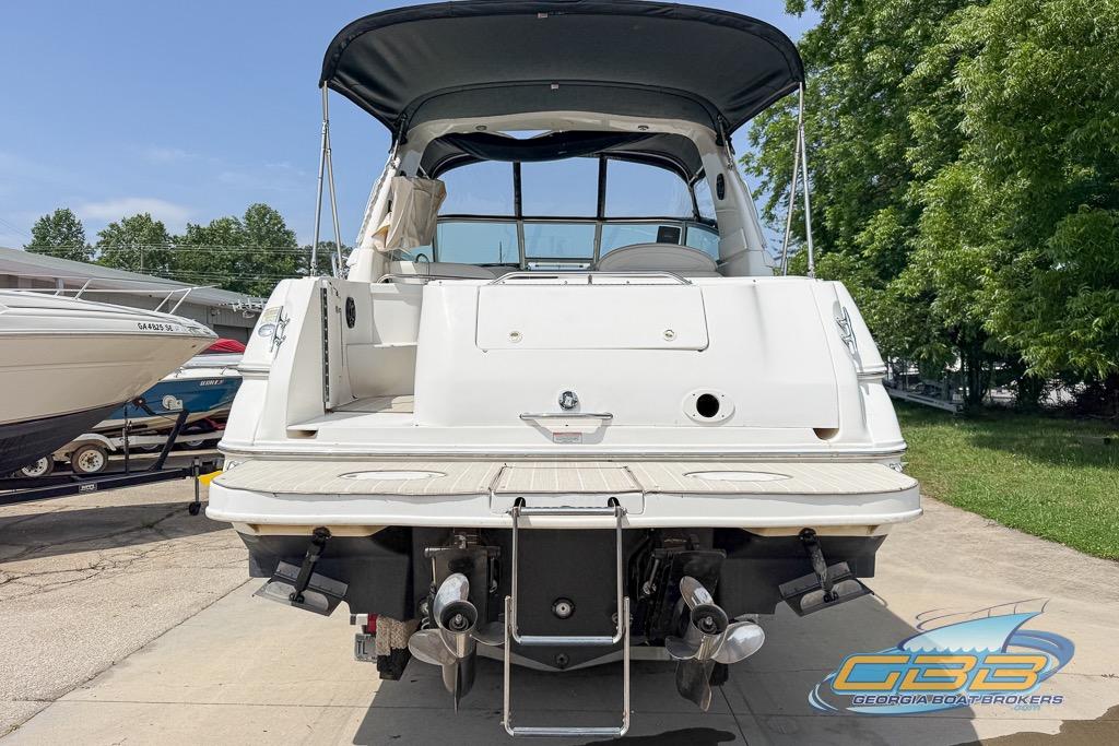 1999 Sea Ray 290 Sundancer boat with canopy, docked outdoors on a sunny day.
