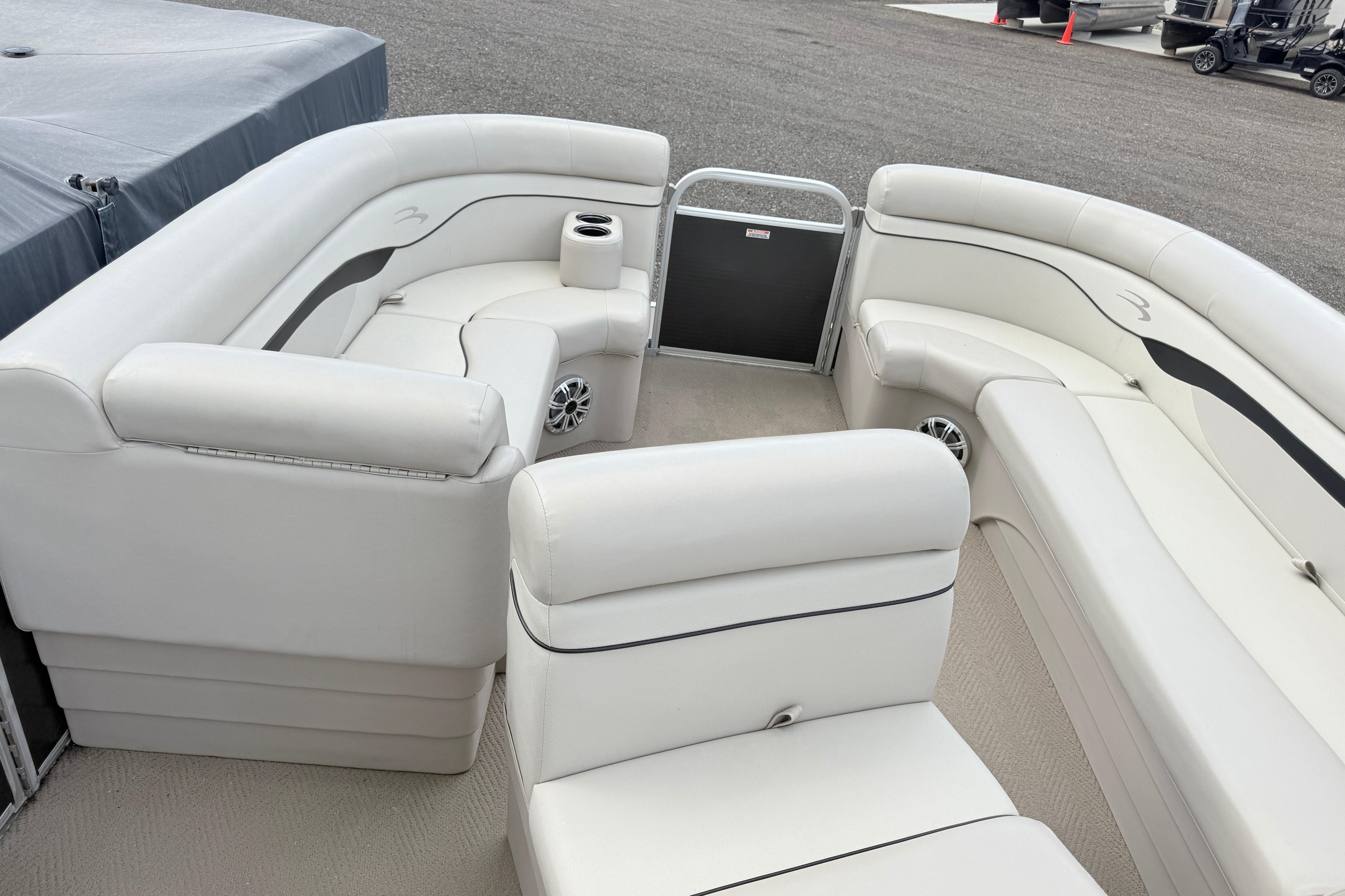 2015 Bennington 24SSLX pontoon boat interior with white seating and cup holders.