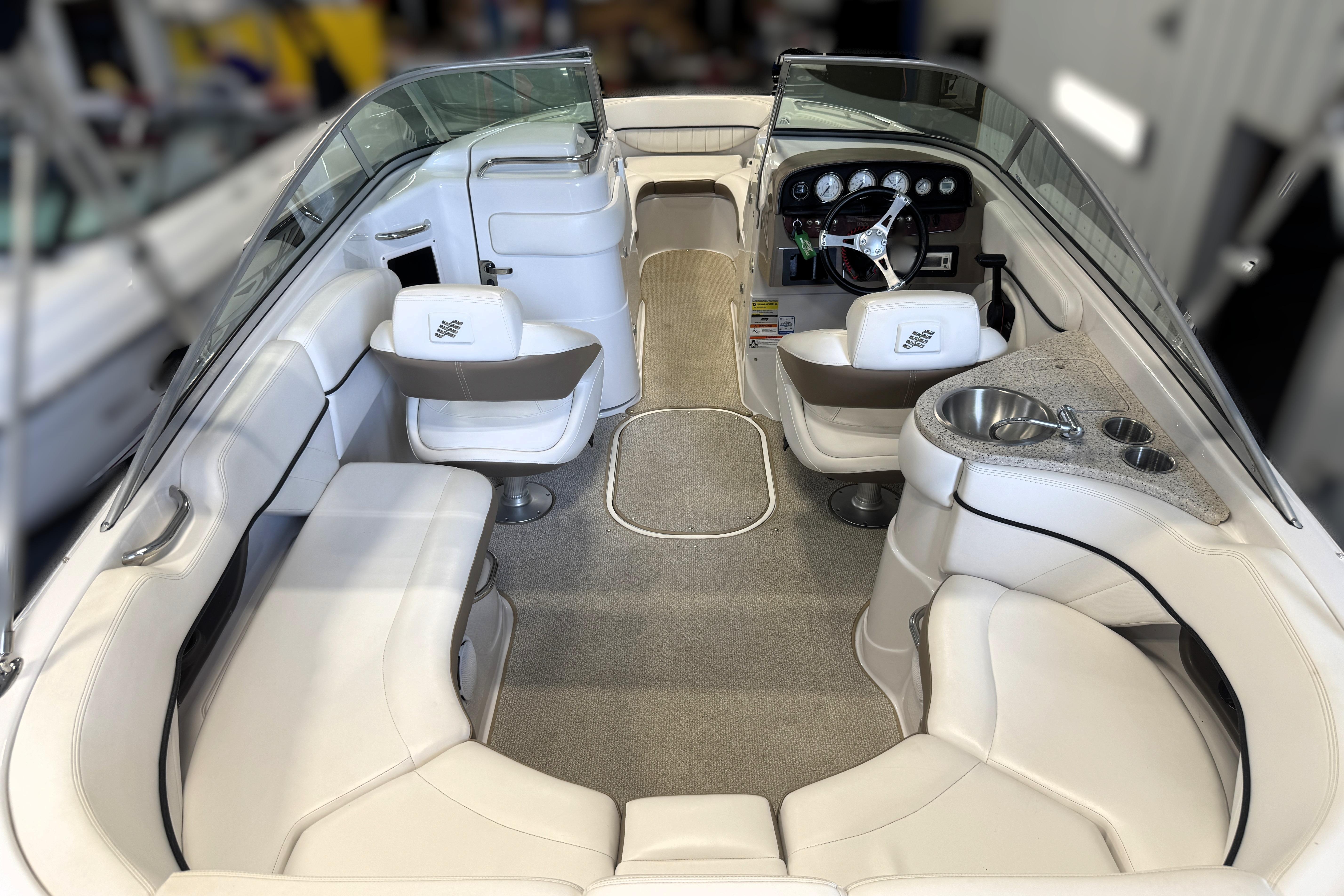 2008 Four Winns H240 boat interior with white seating and steering console.