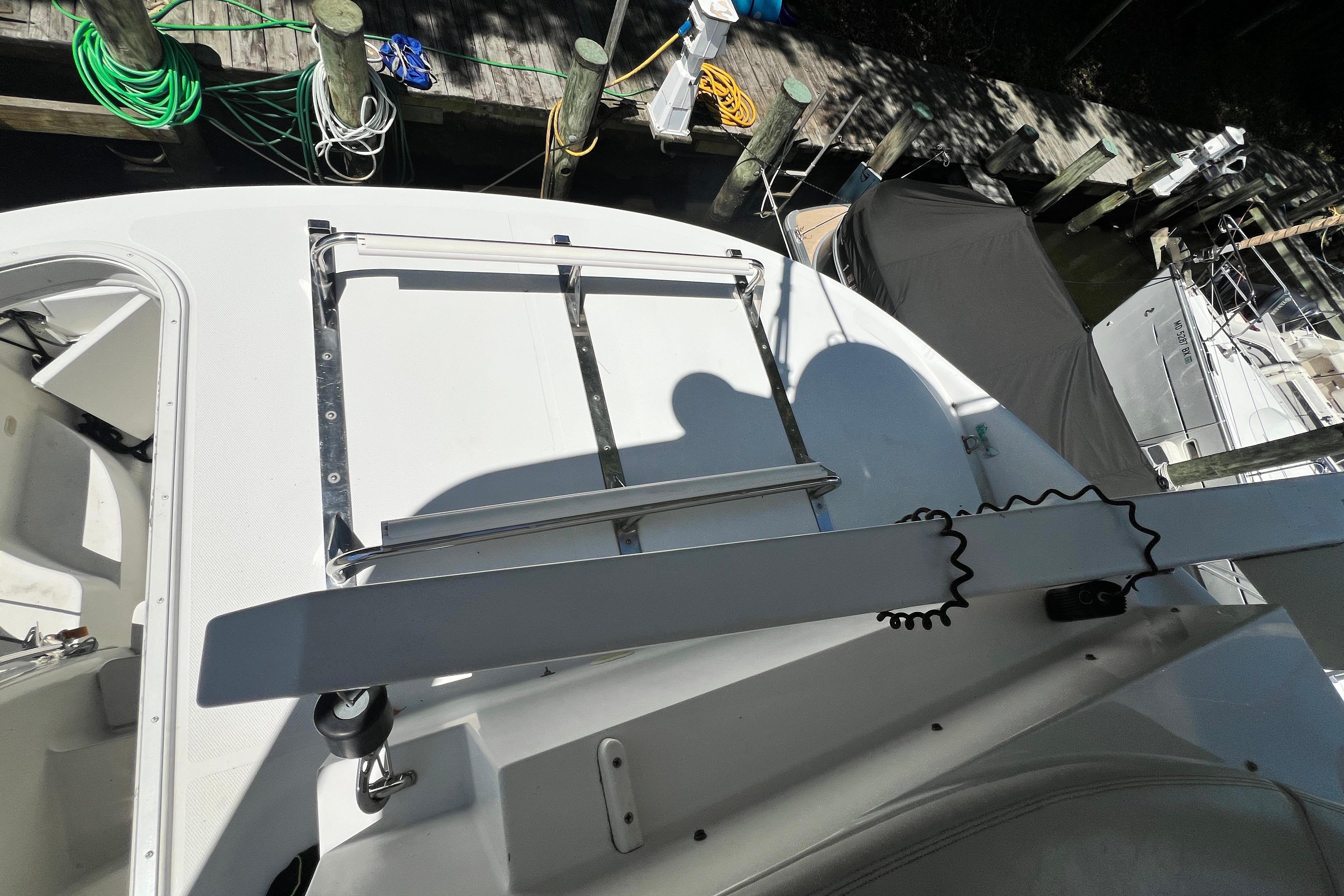2003 Carver 450 Voyager Pilothouse deck with docked boats and coiled ropes.