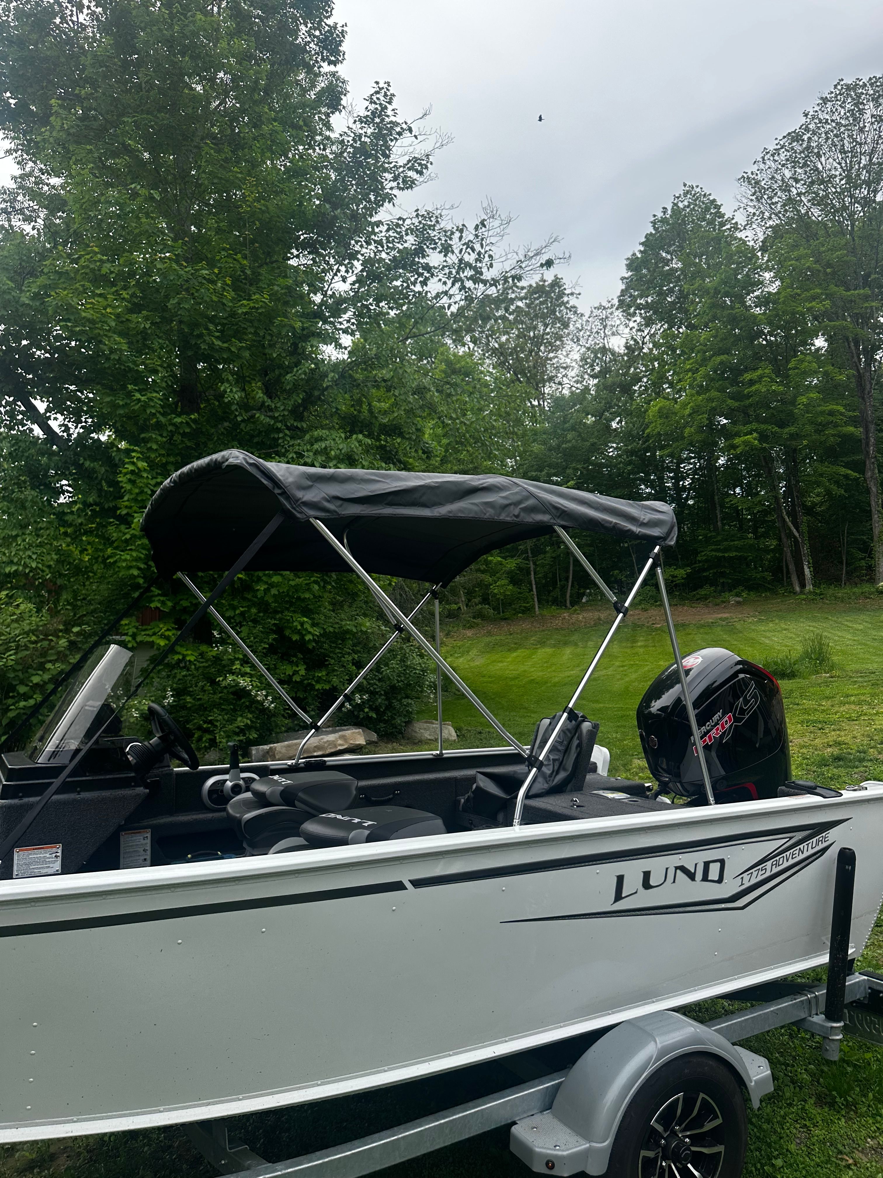 2025 Lund 1775 Adventure SS boat parked in greenery.