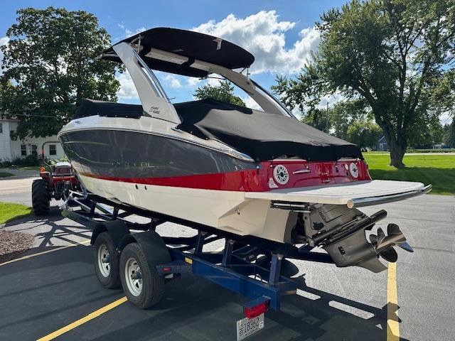 2025 Regal LS4 boat on trailer, black and red design, parked outdoors.