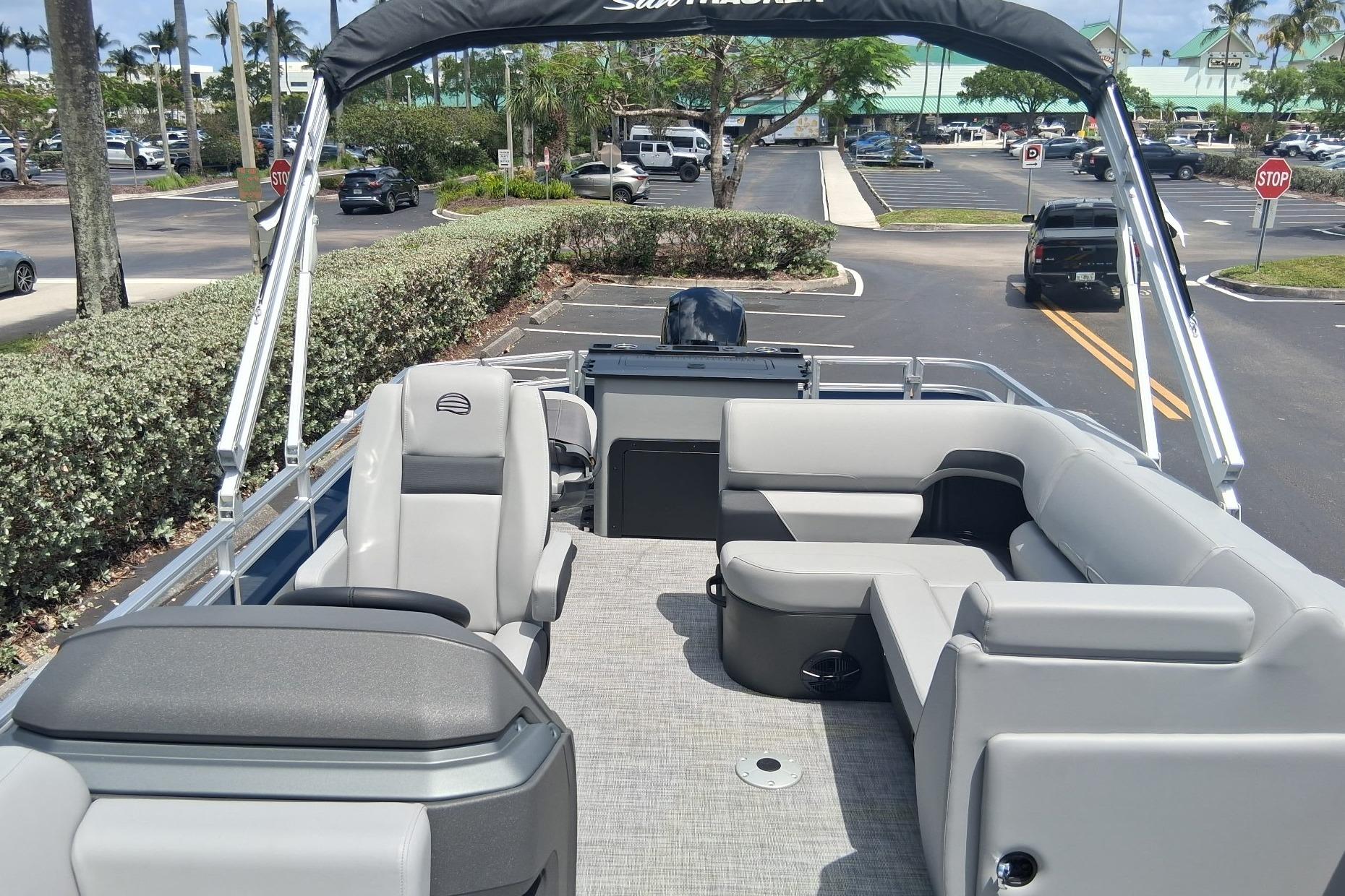2026 Sun Tracker SportFish 22 DLX pontoon boat interior with gray seating and canopy.