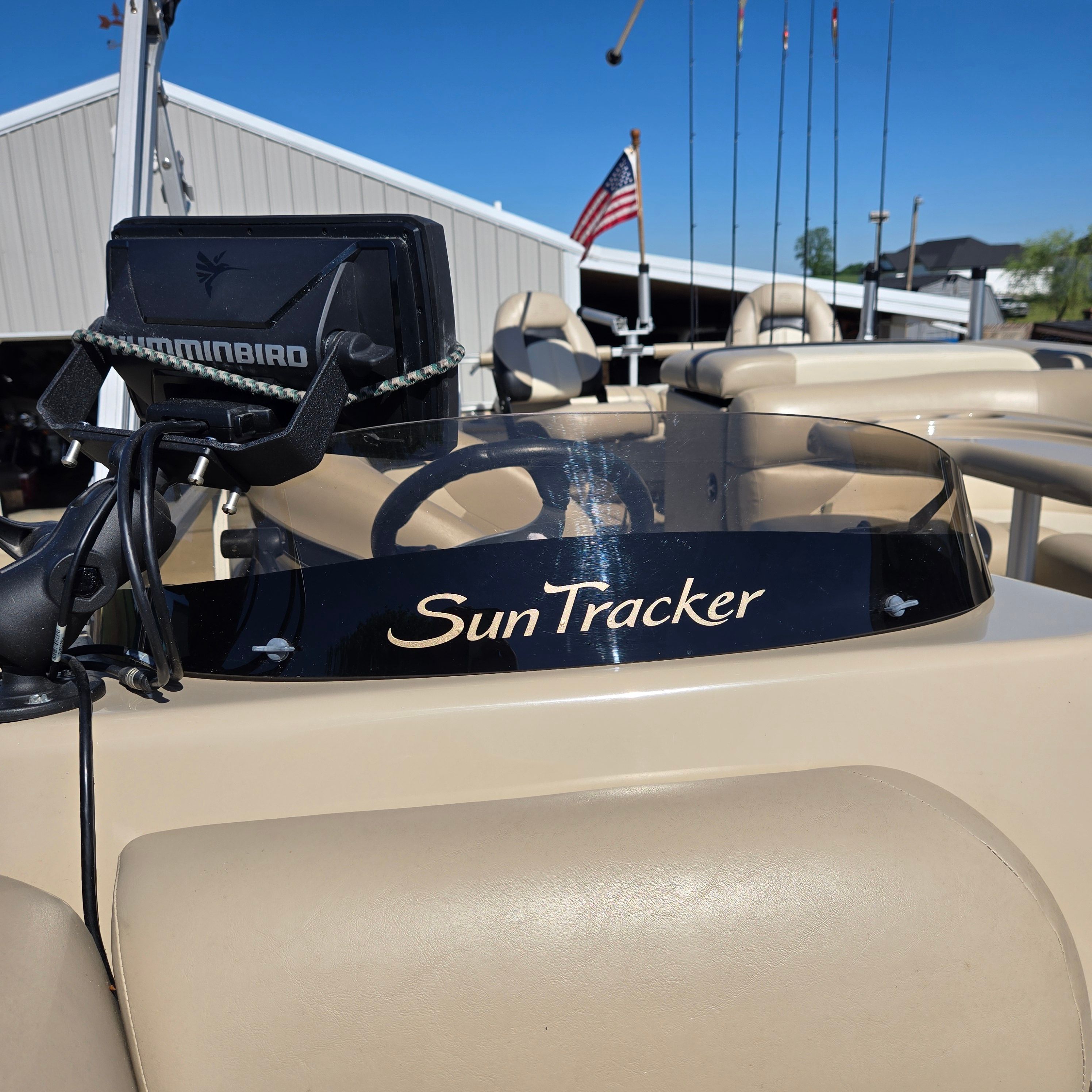 The image shows the helm of a 2012 Sun Tracker Fishin' Barge 24 DLX with a Humminbird fish finder.