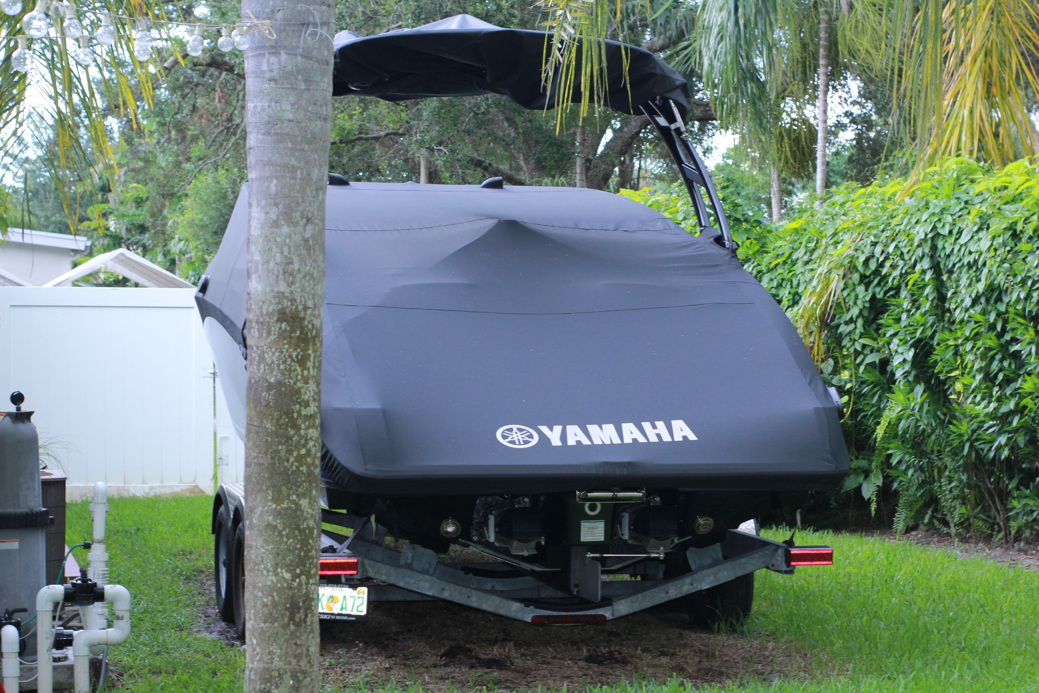 2016 Yamaha AR240 boat covered and parked in a garden.