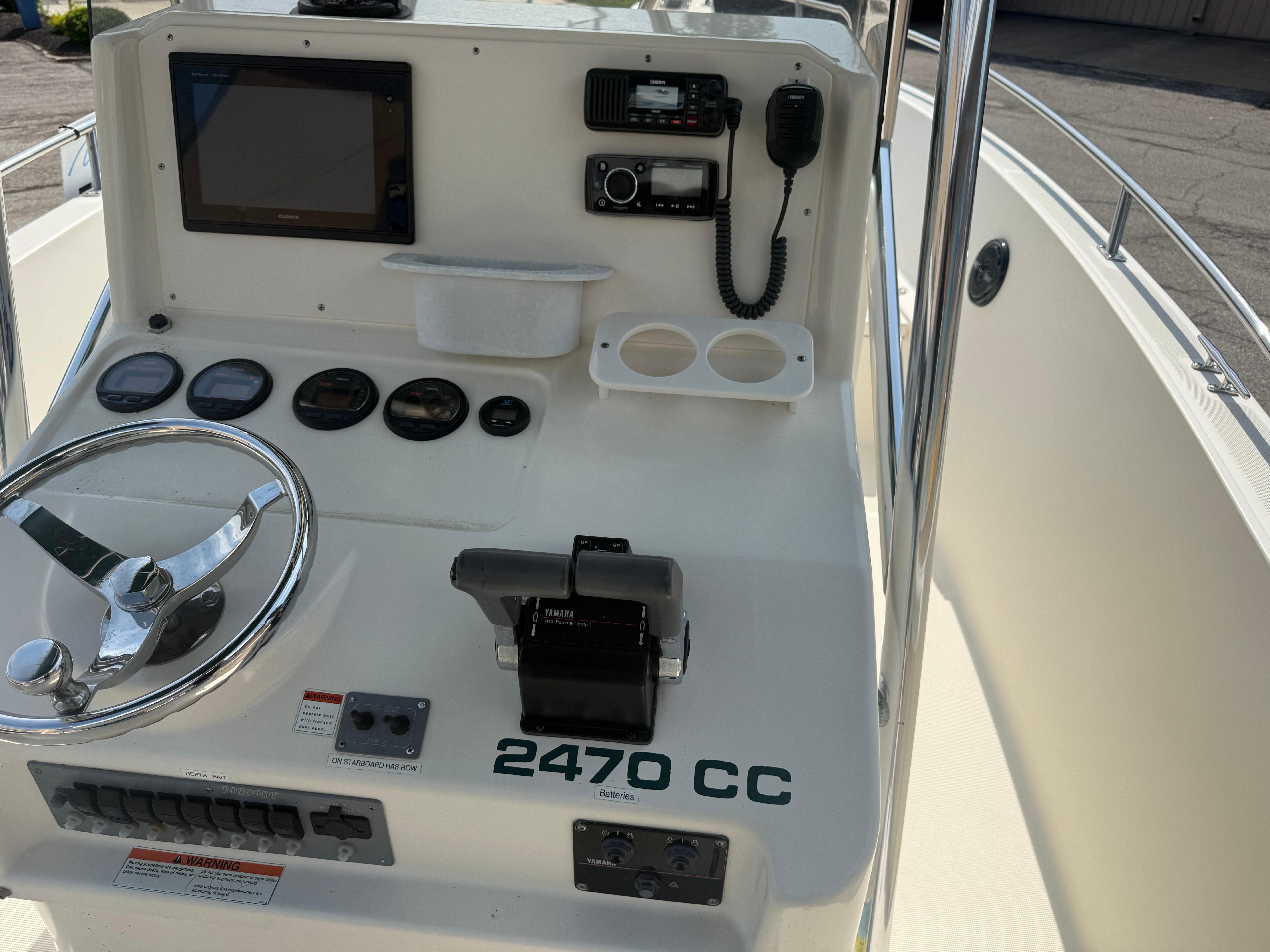 Center console of a 2002 Pursuit 2470 CC boat with steering wheel and controls.
