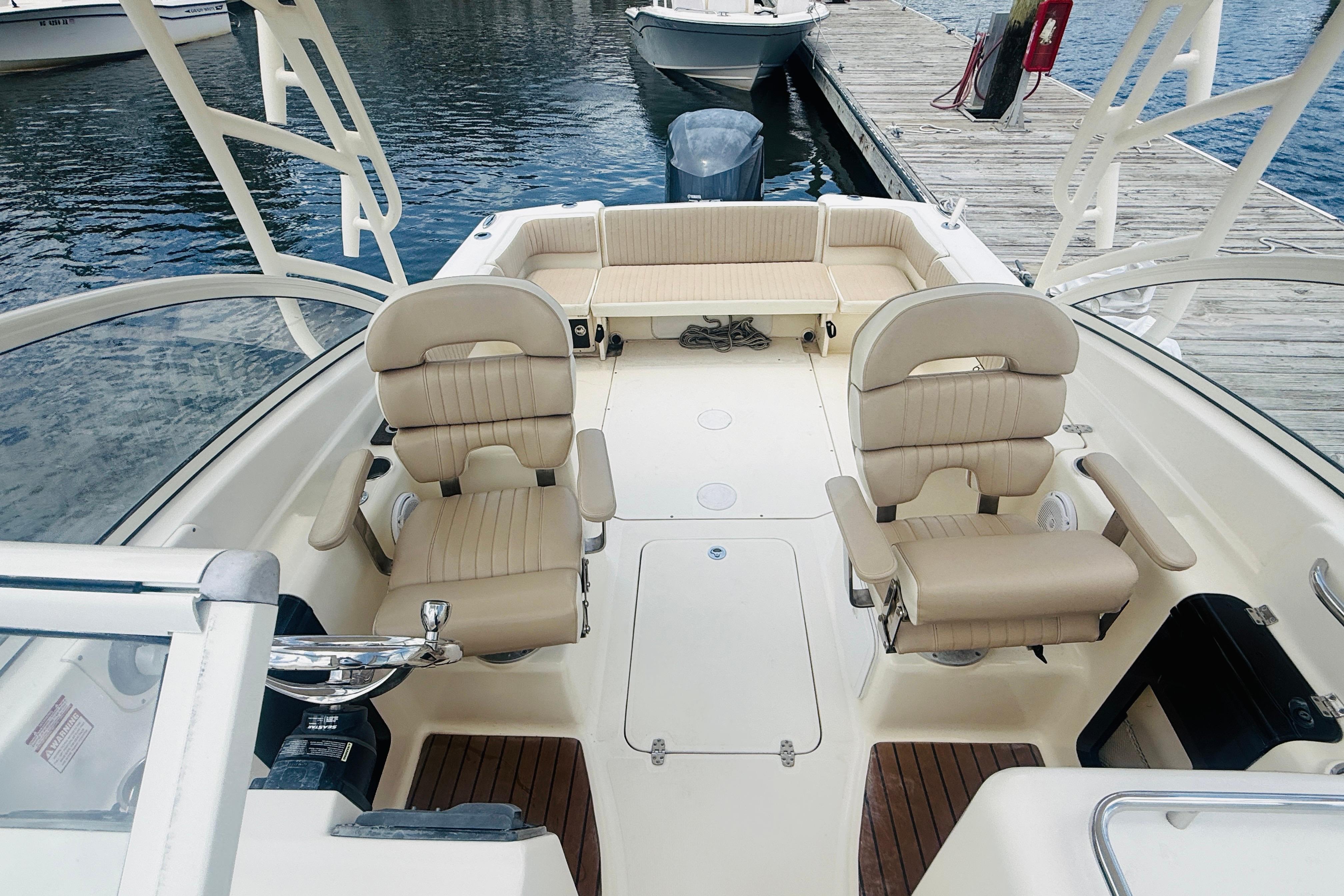 2012 Scout 245 Dorado boat interior with beige seating, docked by the water.