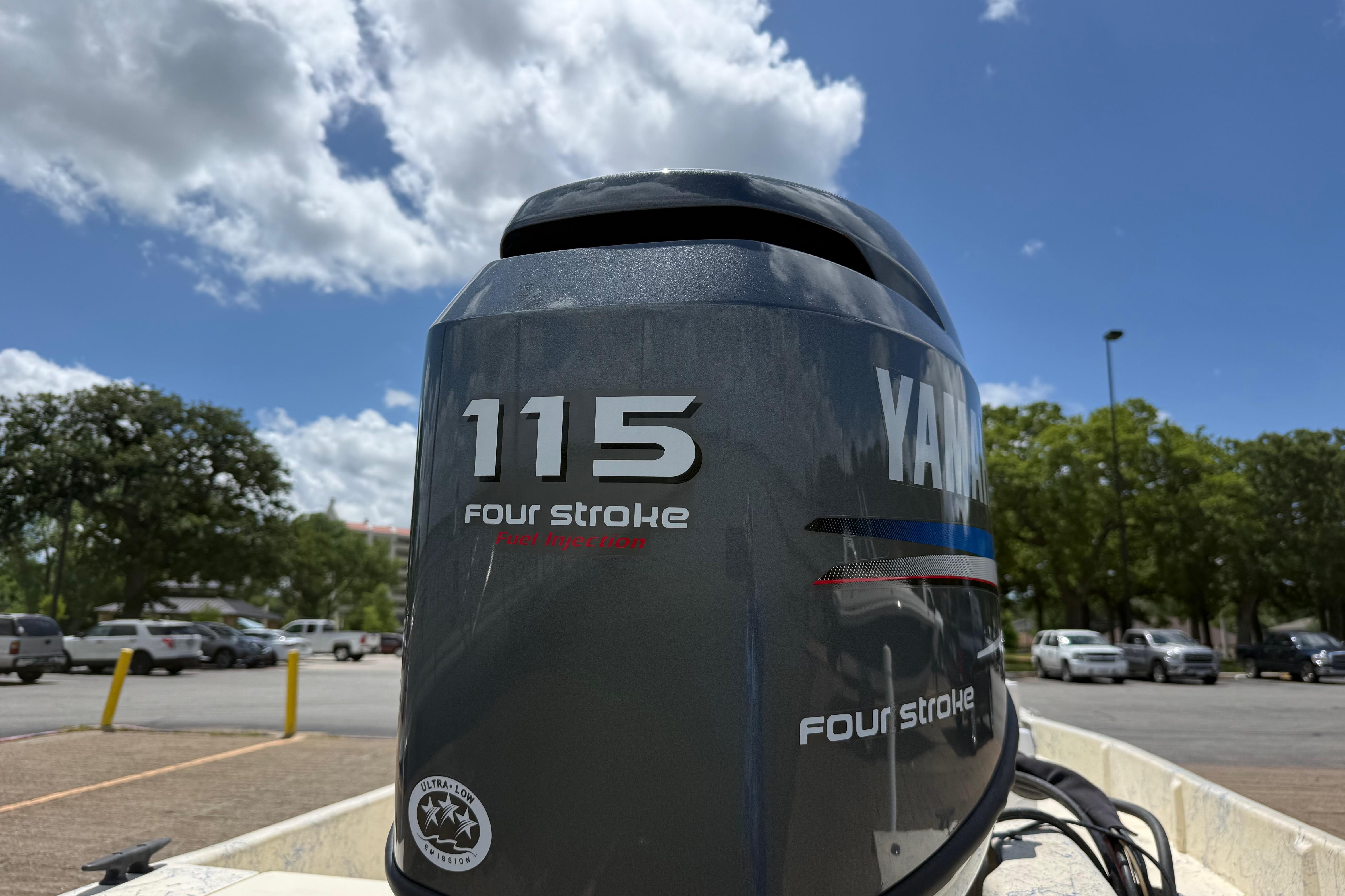 Yamaha 115 four-stroke outboard motor on a 2007 Flats Cat 19 boat, under blue sky.
