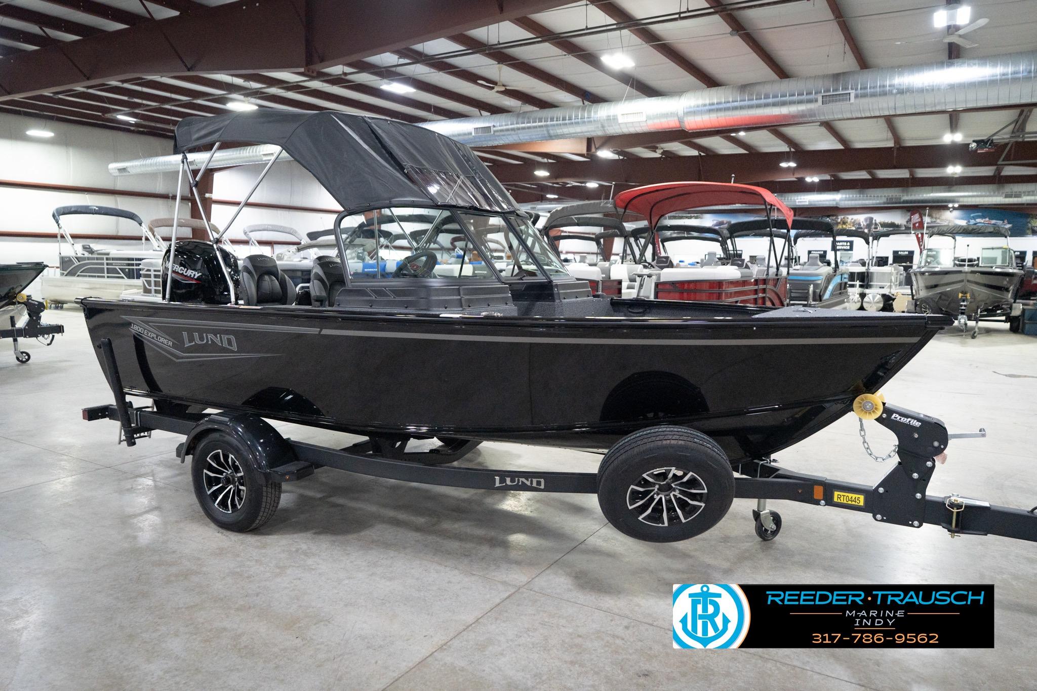 2026 Lund 1800 Explorer Sport boat on trailer in showroom setting.