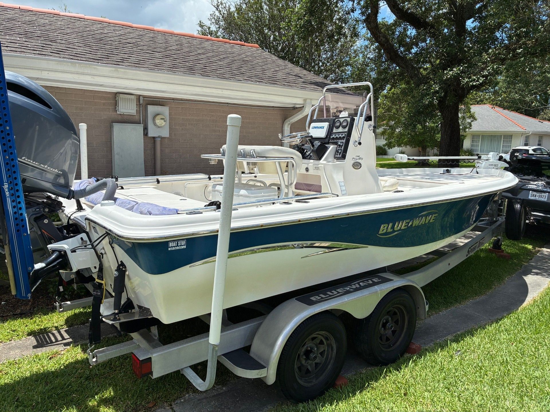 A 2018 Custom 2200 Pure Bay boat on a trailer, parked in a residential area.