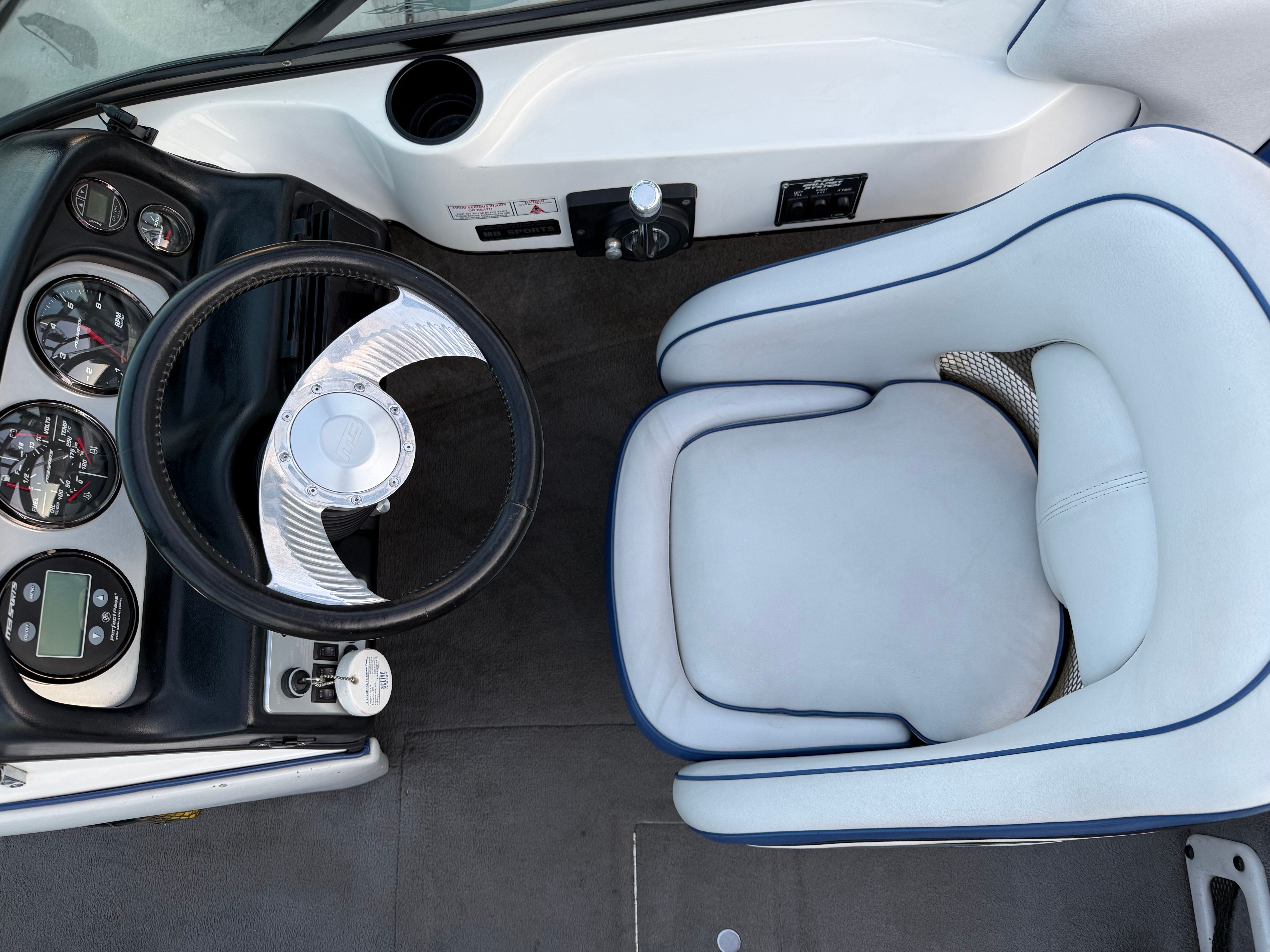 Interior of a 2004 MB Sports 220 boat with steering wheel and seat.