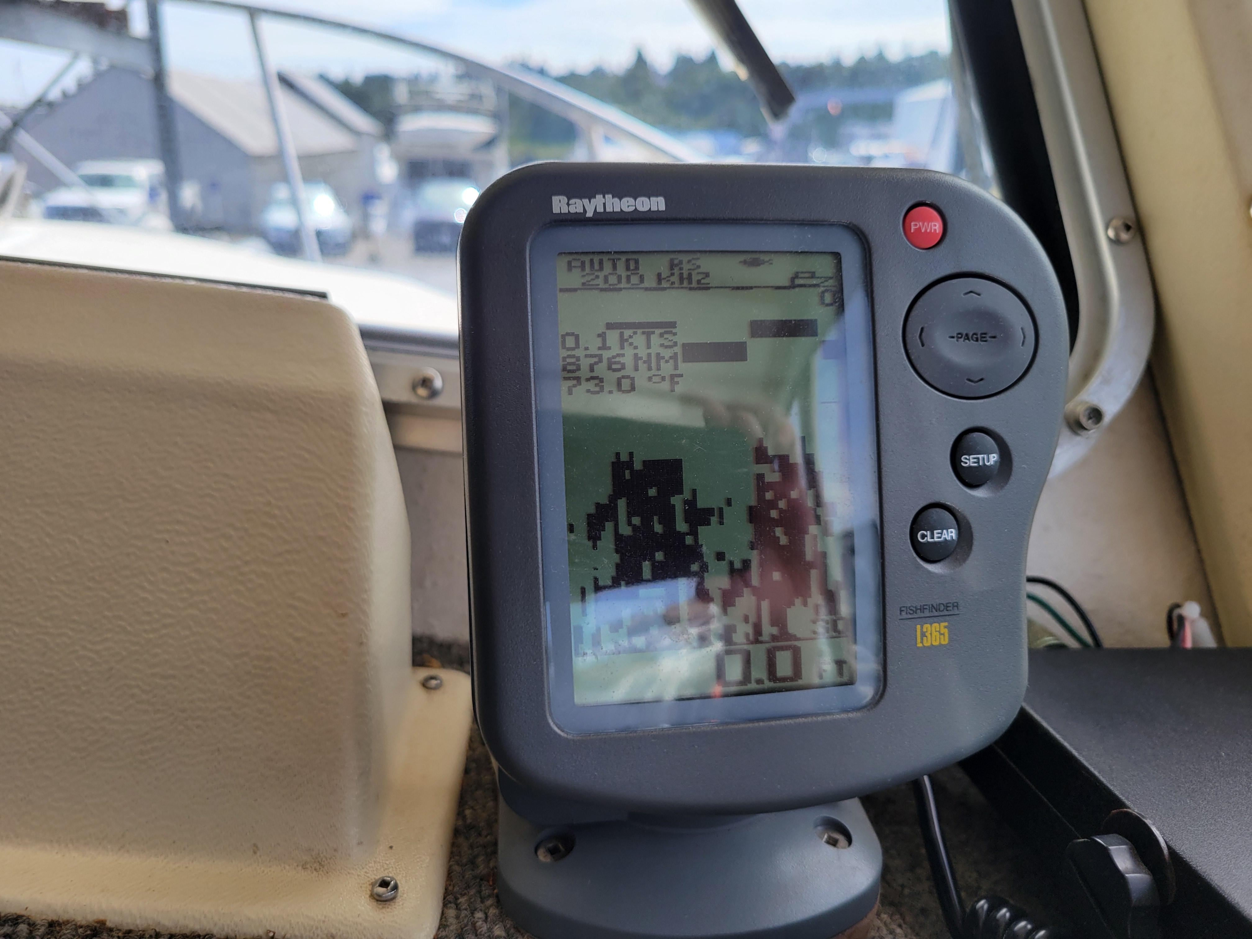 Raytheon fishfinder display on 1999 SeaSport 2400 XL Limited boat dashboard.