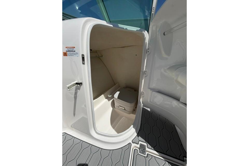 2024 Robalo R207 Dual Console boat interior storage compartment with open door.