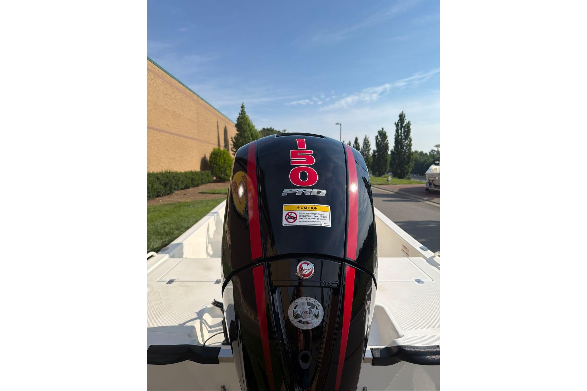 Outboard motor on a 2026 Mako Pro Skiff 19 CC boat, parked outdoors.