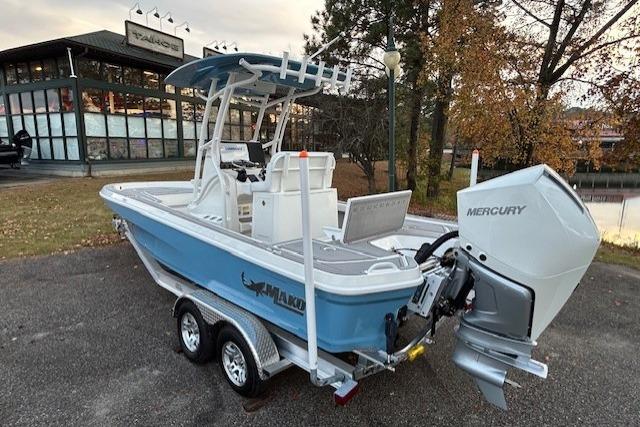 2025 Mako 24 APEX boat with Mercury engine, parked outdoors near a building.