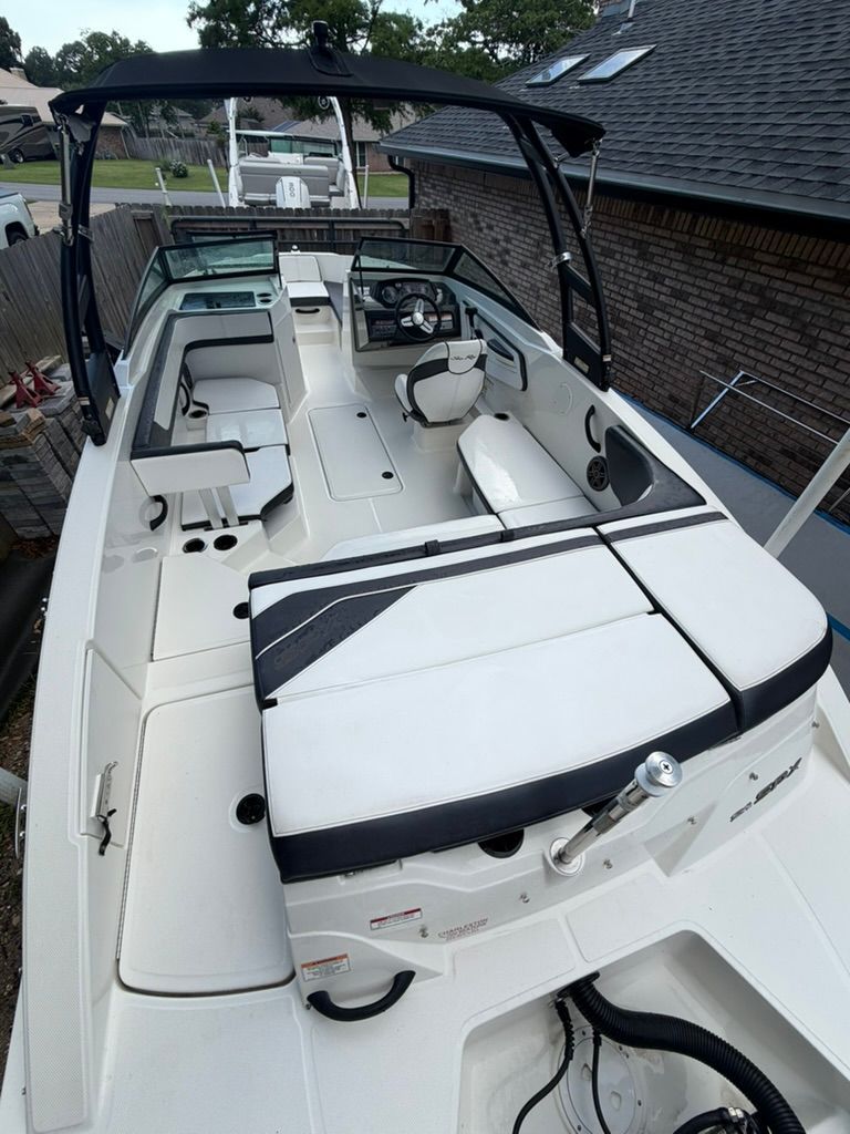 A Sea Ray SPX 210 Outboard boat with white upholstery and black canopy.