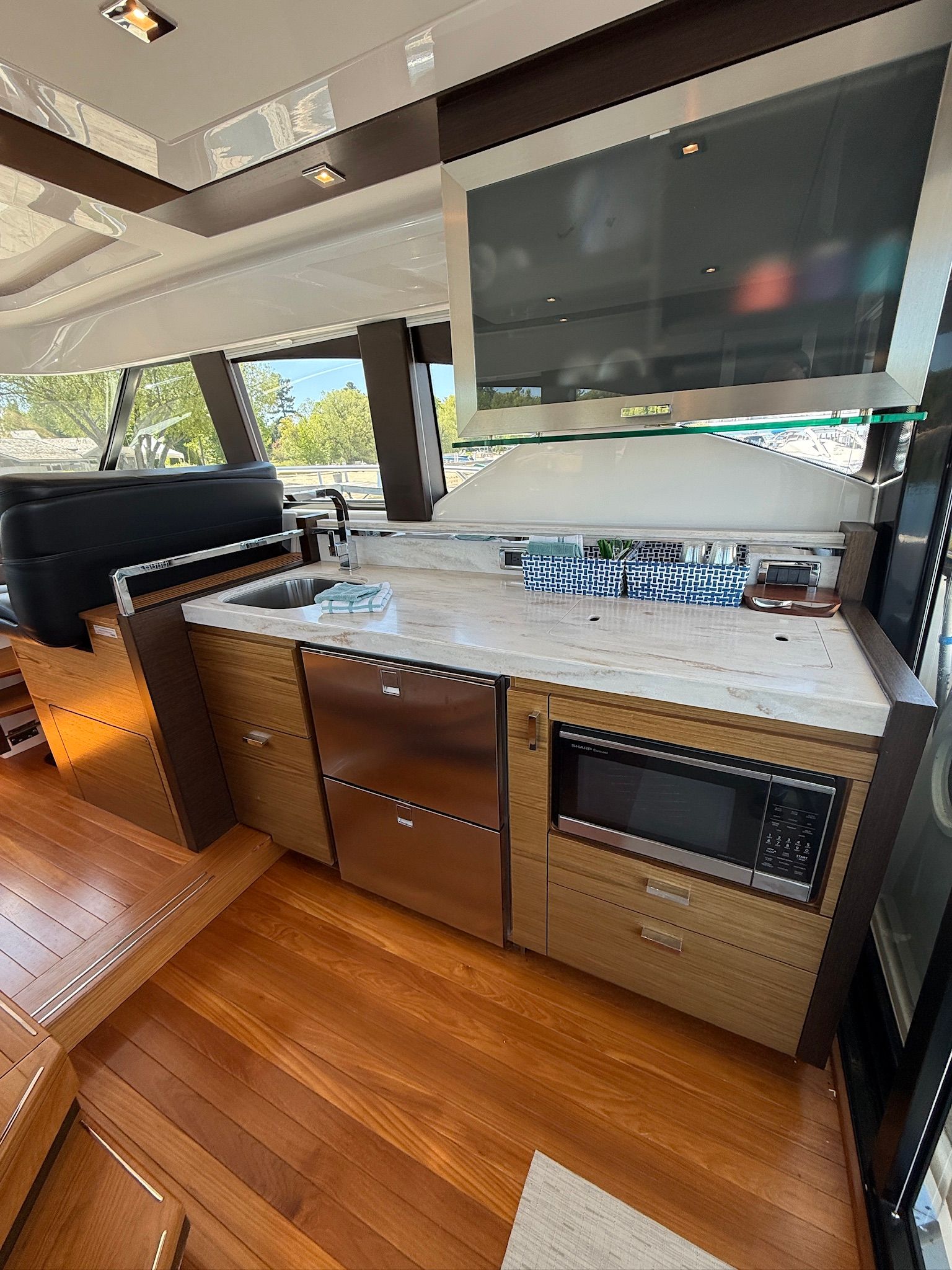 The galley of a 2017 Tiara Yachts C44 Coupe with wooden flooring and modern appliances.
