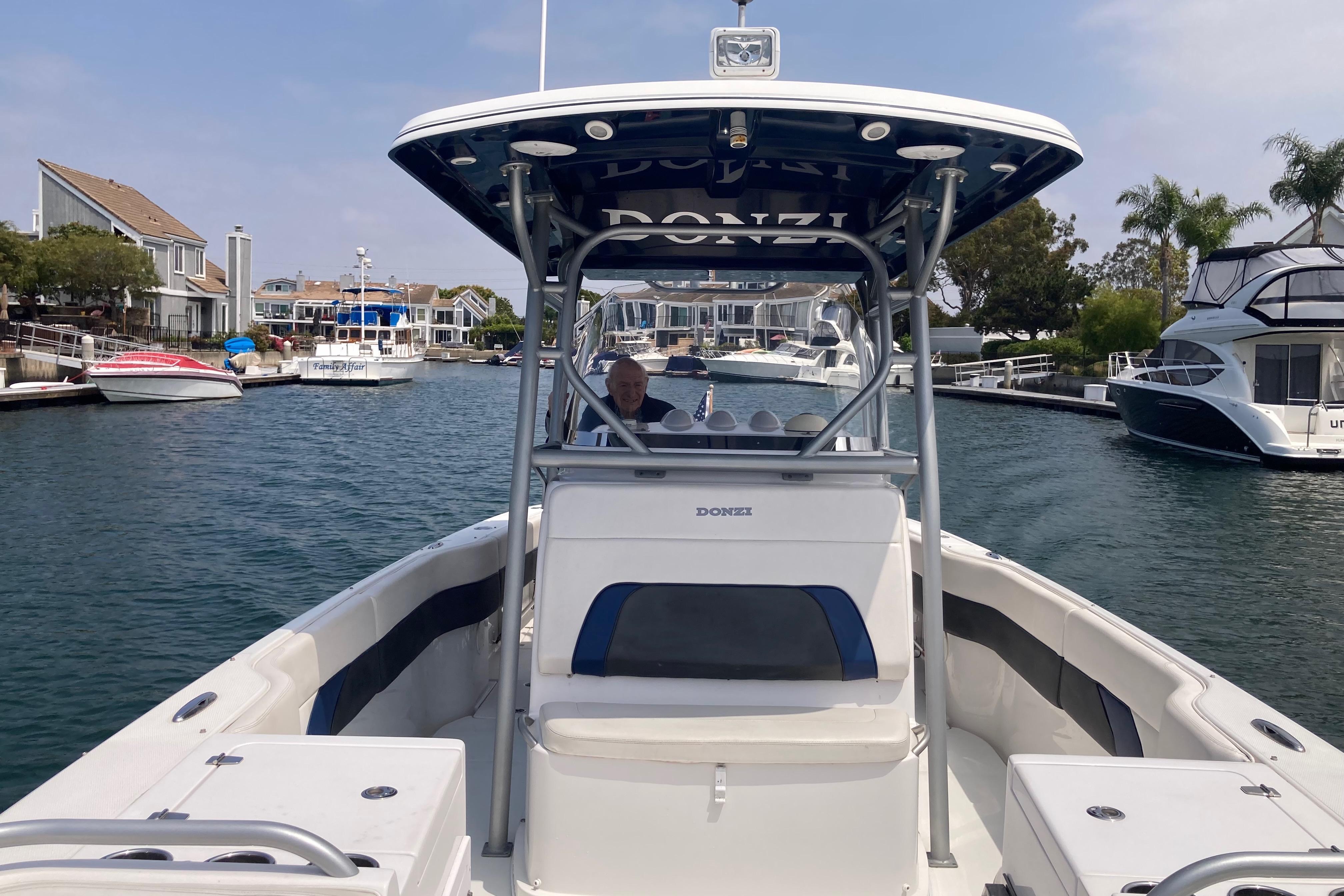 2011 Donzi 38 ZFX Open boat cruising in a marina with waterfront homes.