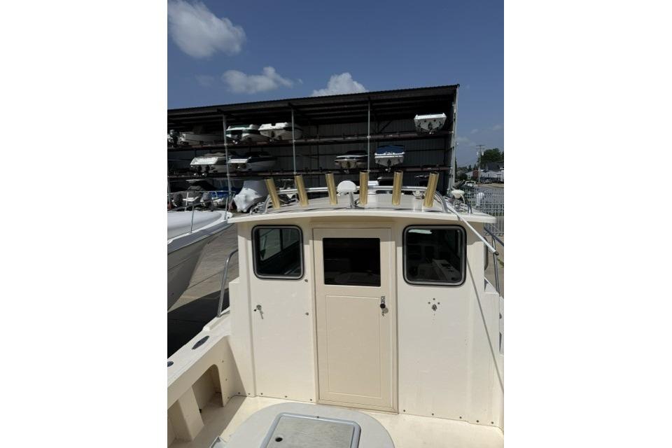 2006 Parker 2520 SL Sport Cabin boat docked, showcasing cabin and rod holders.