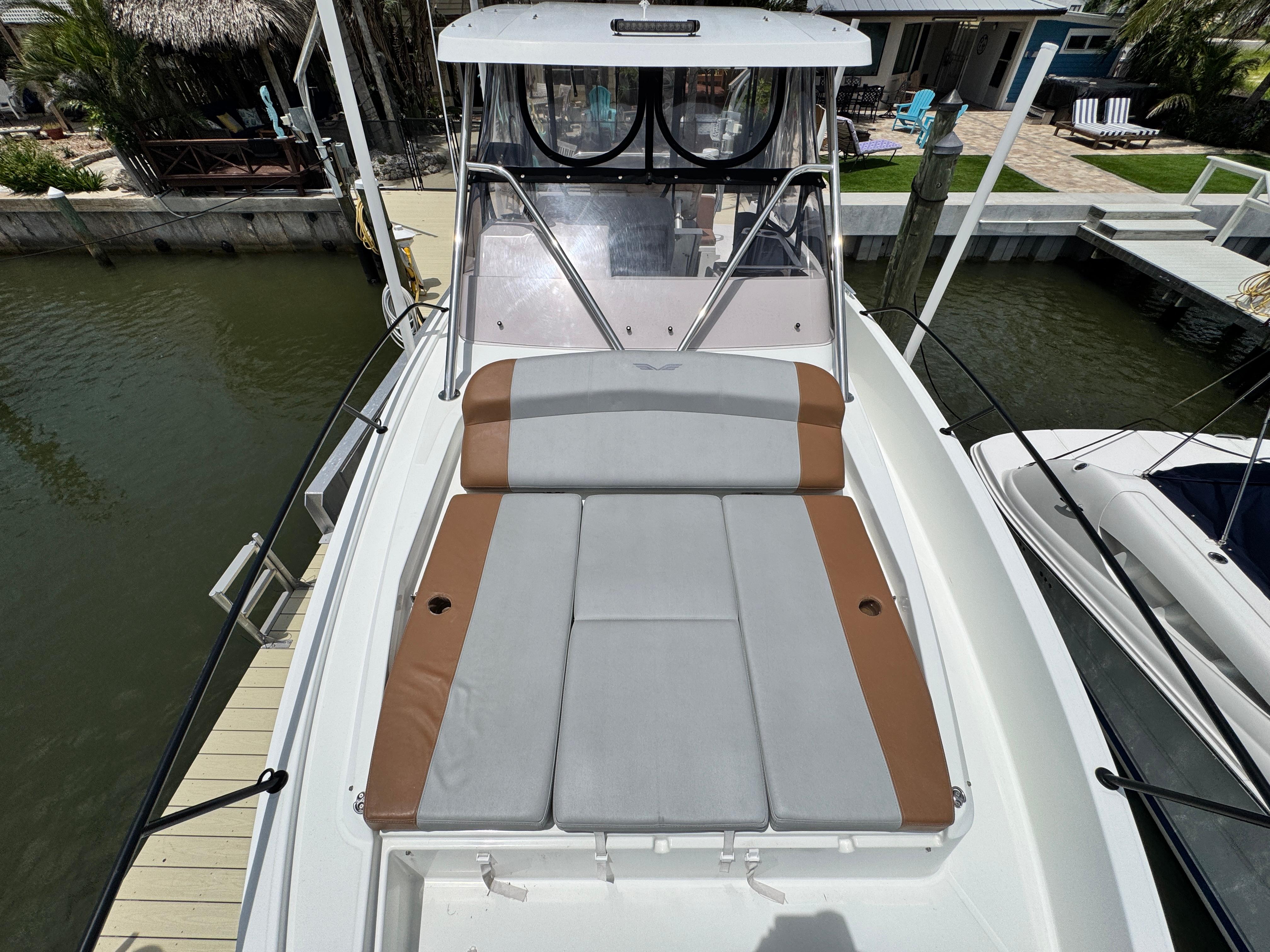 2022 Beneteau Flyer 9 SUNdeck boat with cushioned sunbathing area, docked by the water.