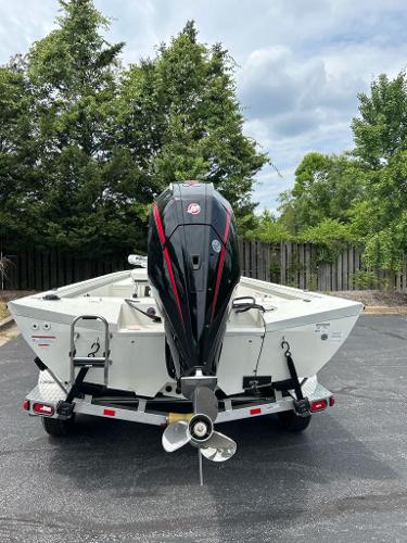 2024 Ranger RB210 boat with outboard motor on trailer, parked outdoors.