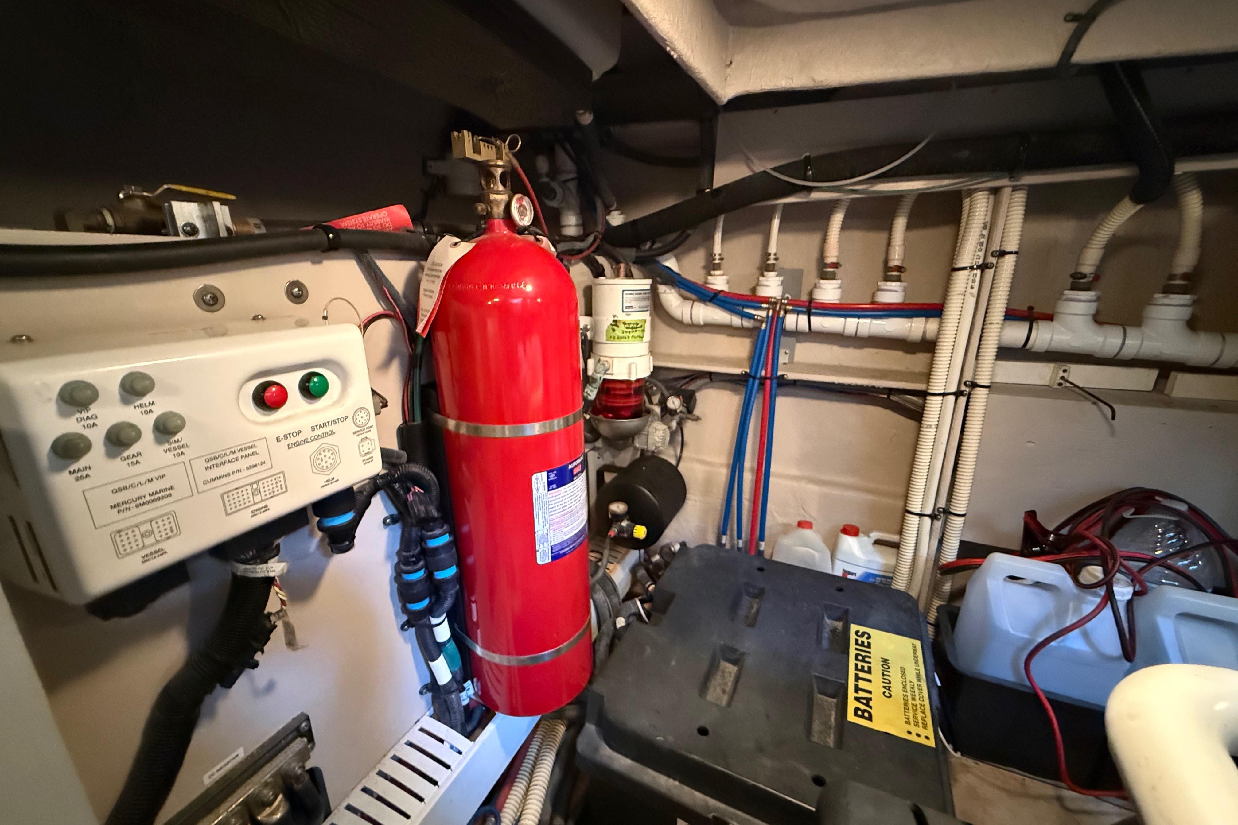 Engine room of 2016 Sea Ray Sundancer 510 with fire extinguisher and control panel.