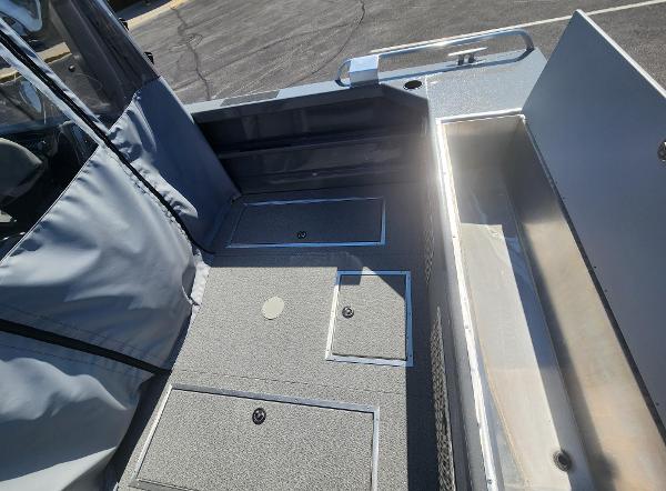 2025 Spartan 200 Astoria boat interior with storage compartments and seating area.