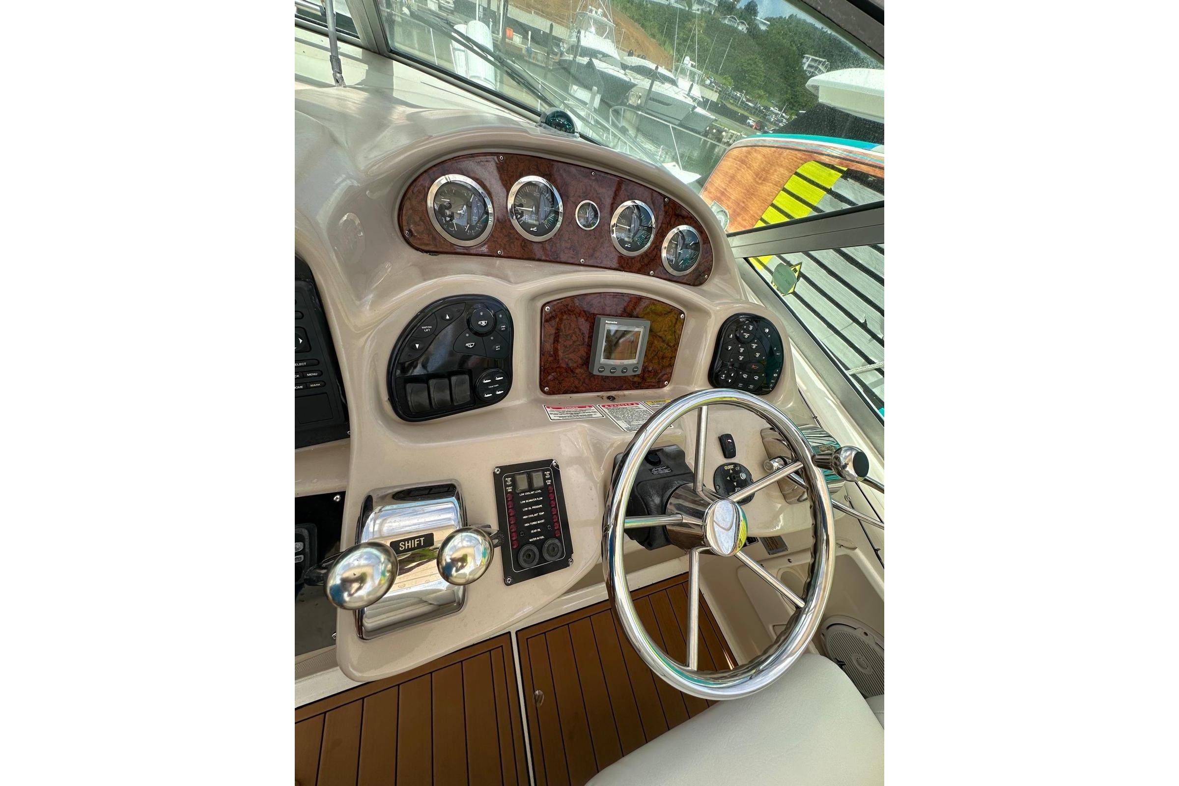 Helm of 2004 Sea Ray 340 Sundancer with gauges, controls, and steering wheel.