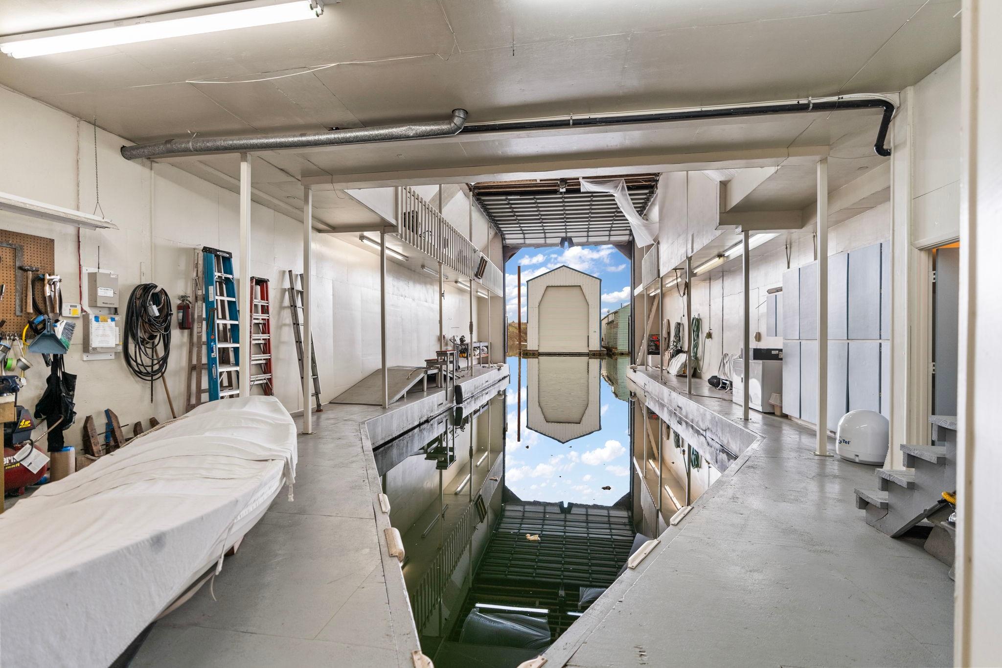 Interior of a 1976 custom boathouse with water channel and storage area.