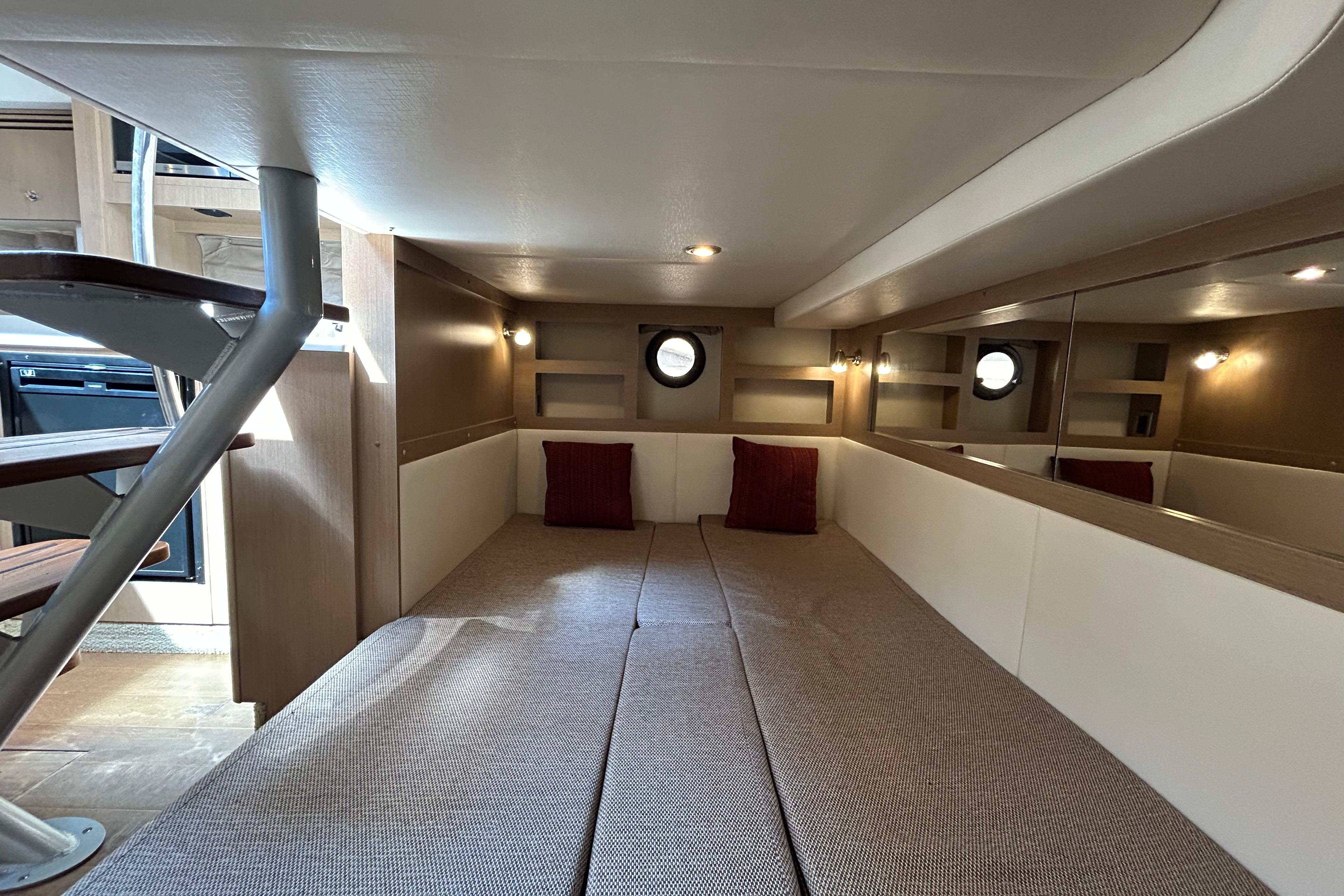 Interior cabin of 2019 Sea Ray Sundancer 350 with cozy bedding and ambient lighting.