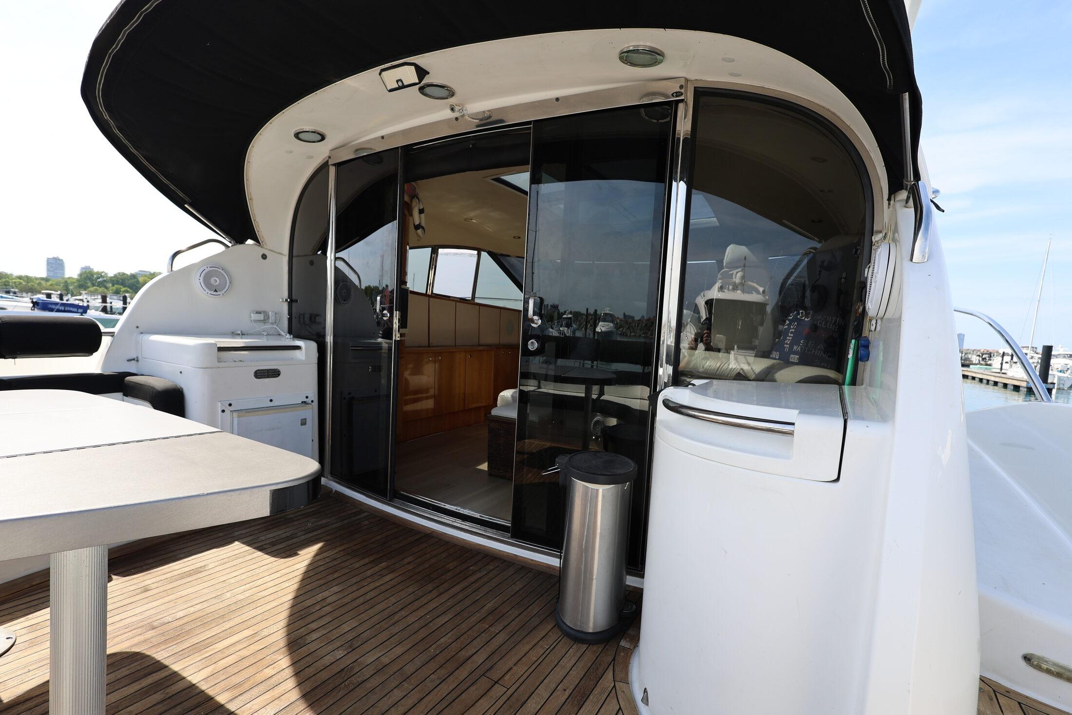 1999 Neptunus 54 Express yacht with open deck and sliding glass doors.