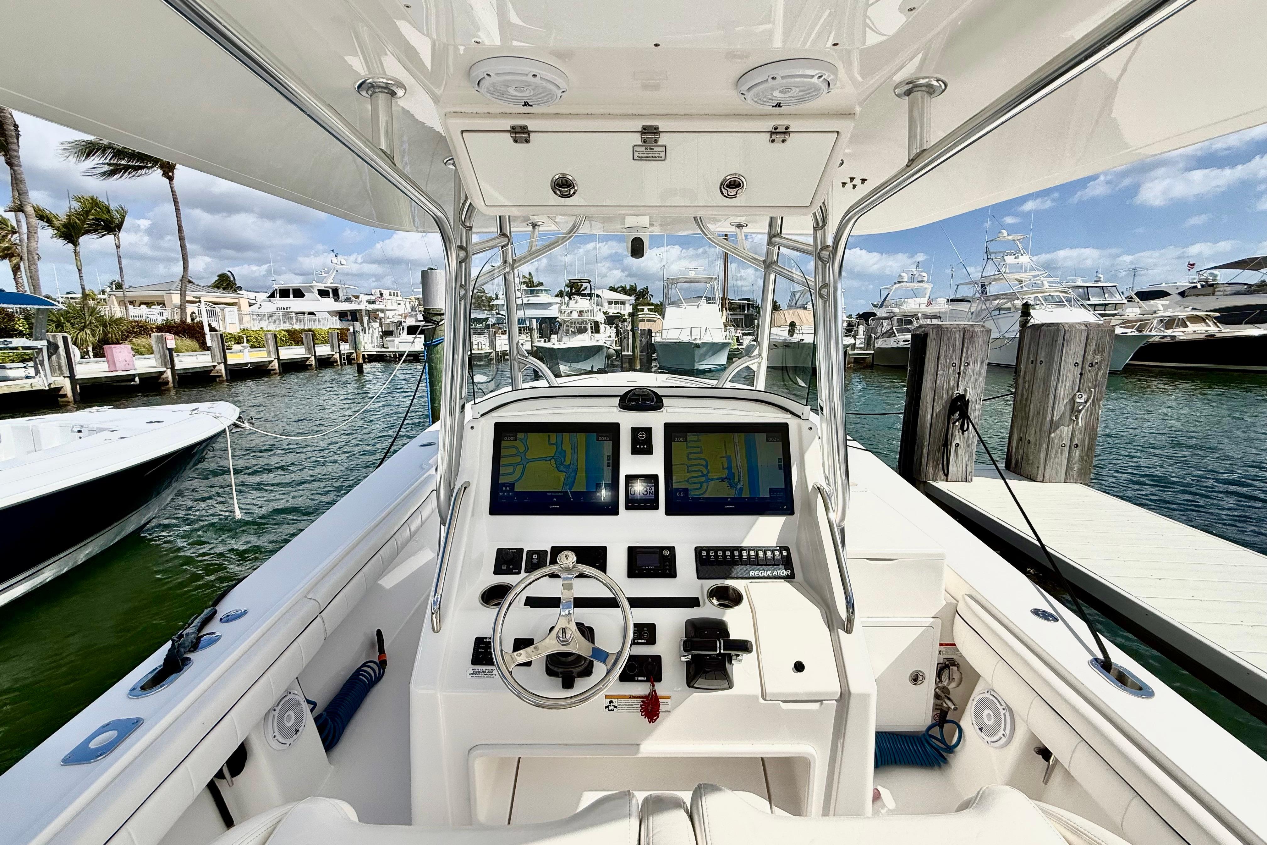 2016 Regulator 34SS boat dashboard with navigation screens, docked at a marina.