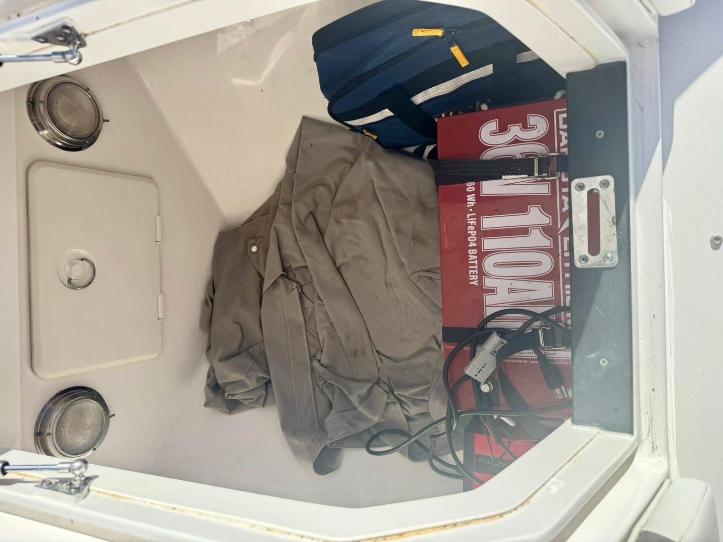 Storage compartment in Intrepid 327 Nomad boat with battery and gear.