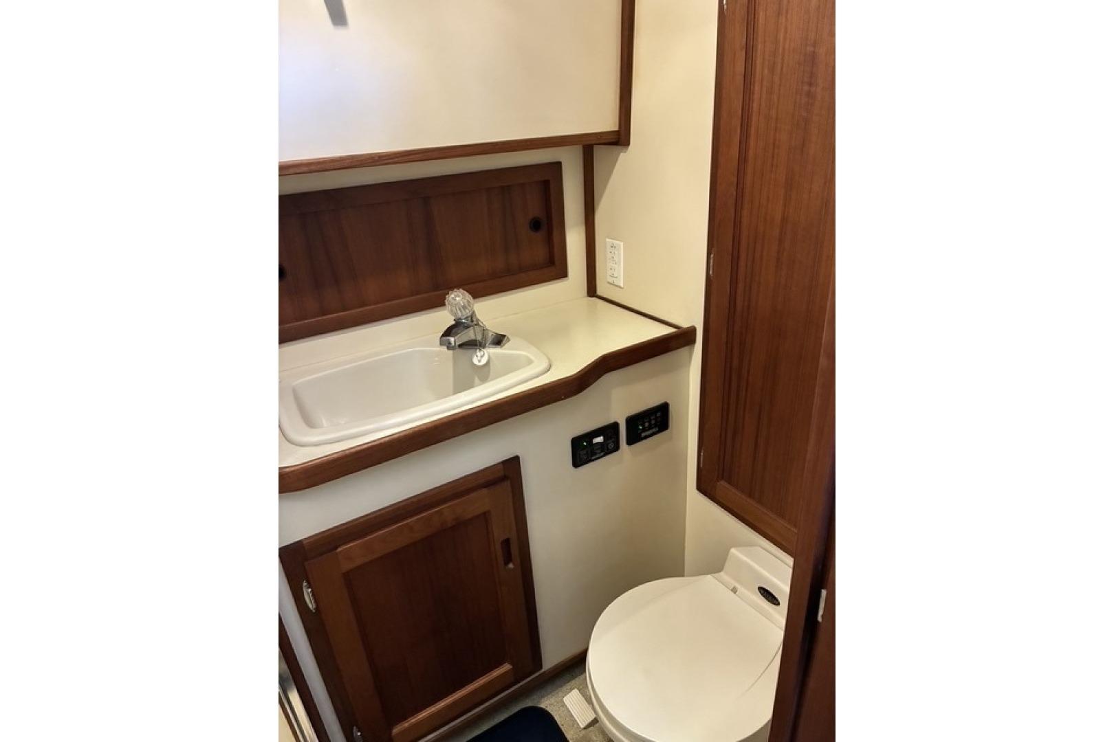 Compact bathroom in a 2000 Nordic Tug 37, featuring a sink and toilet.