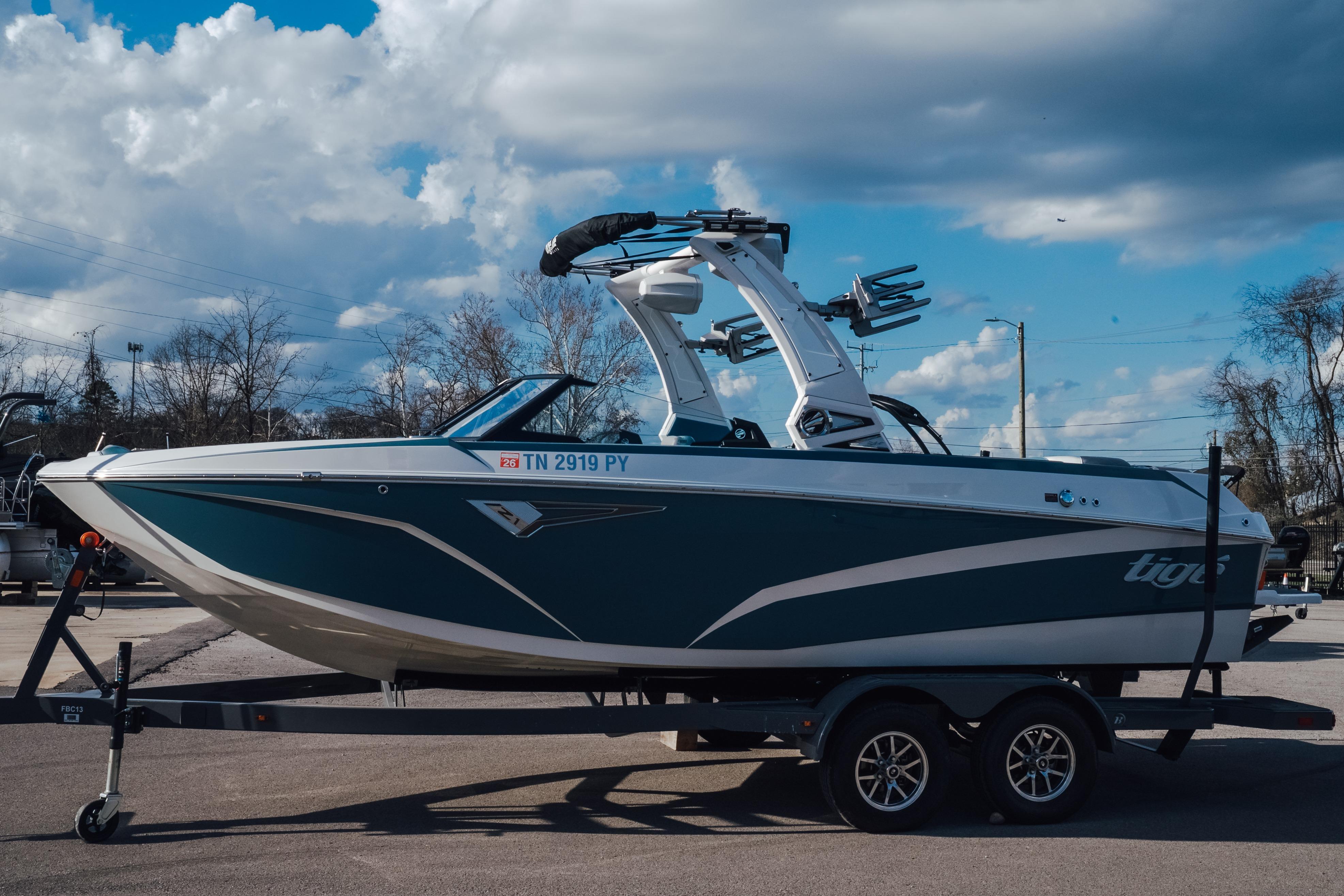 2023 Tigé Z1 boat on trailer under cloudy sky, side view.