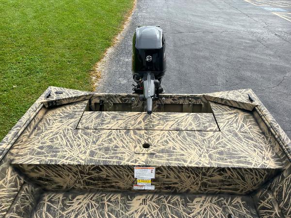 2024 Lowe Roughneck 1660 boat with camouflage design and outboard motor.
