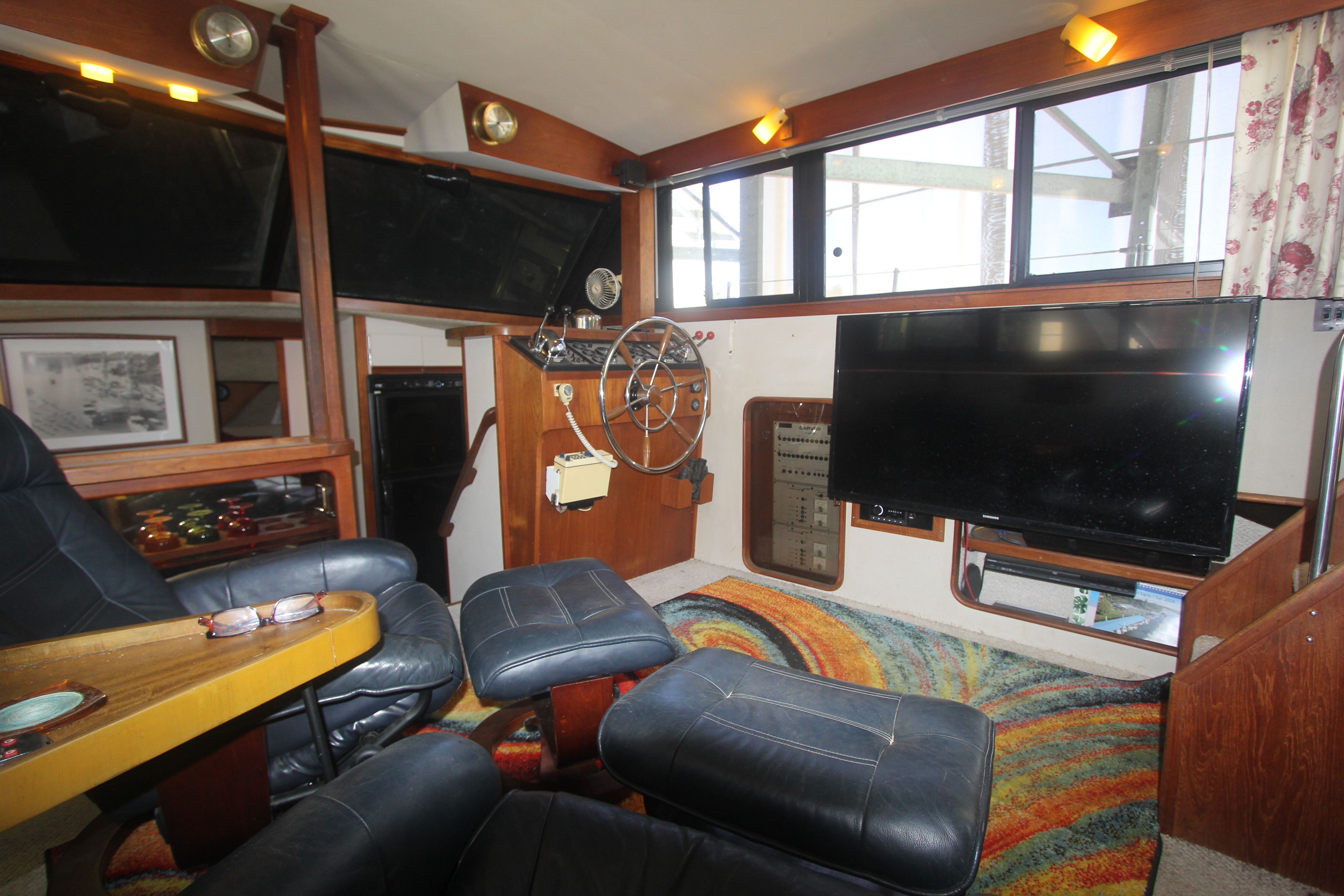 Interior of a 1988 Carver 3607 Aft Cabin Motor Yacht with leather chairs and a TV.