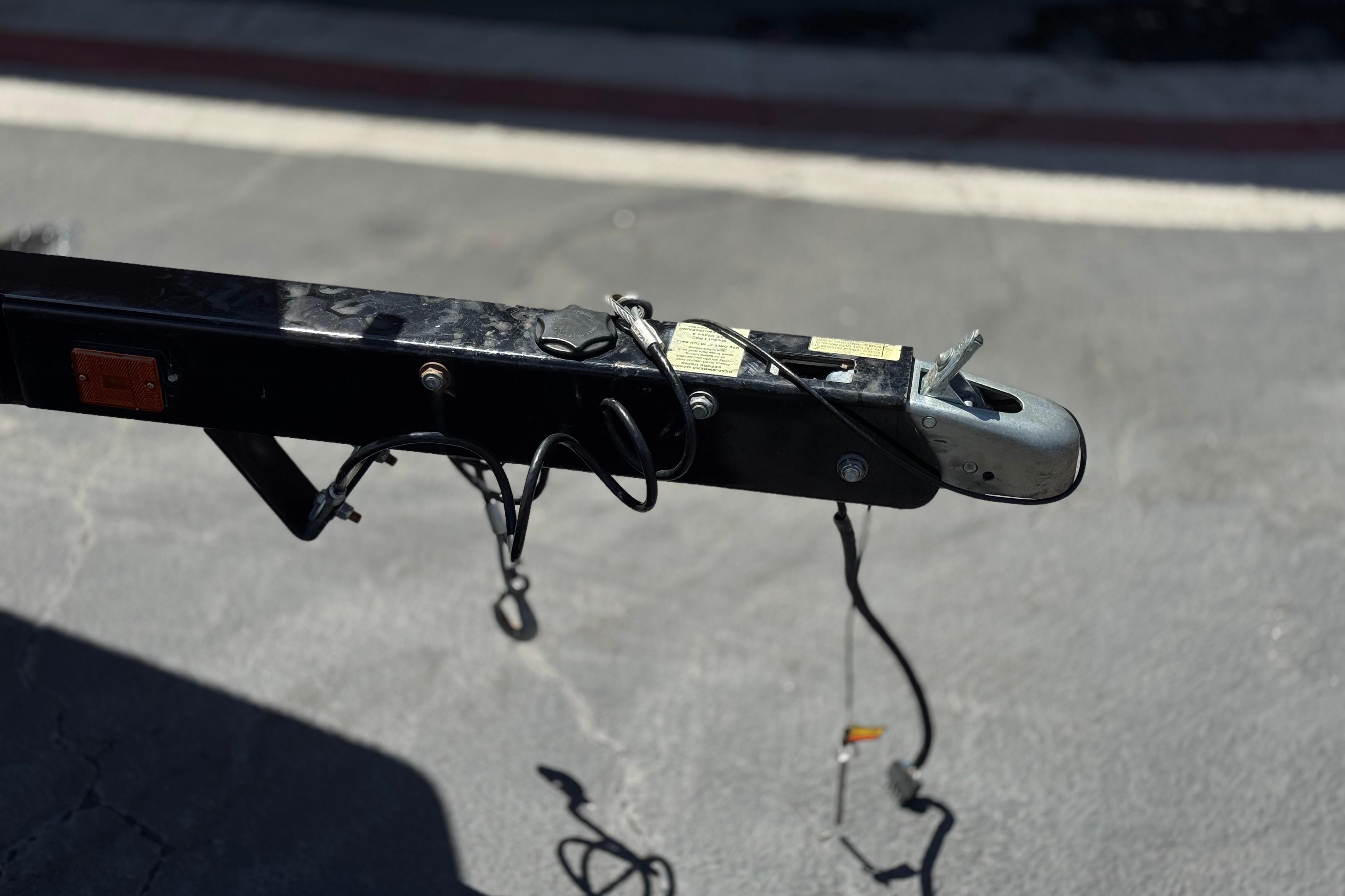 Trailer hitch of a 2017 Scarab 255 H.O. Platinum boat on pavement.