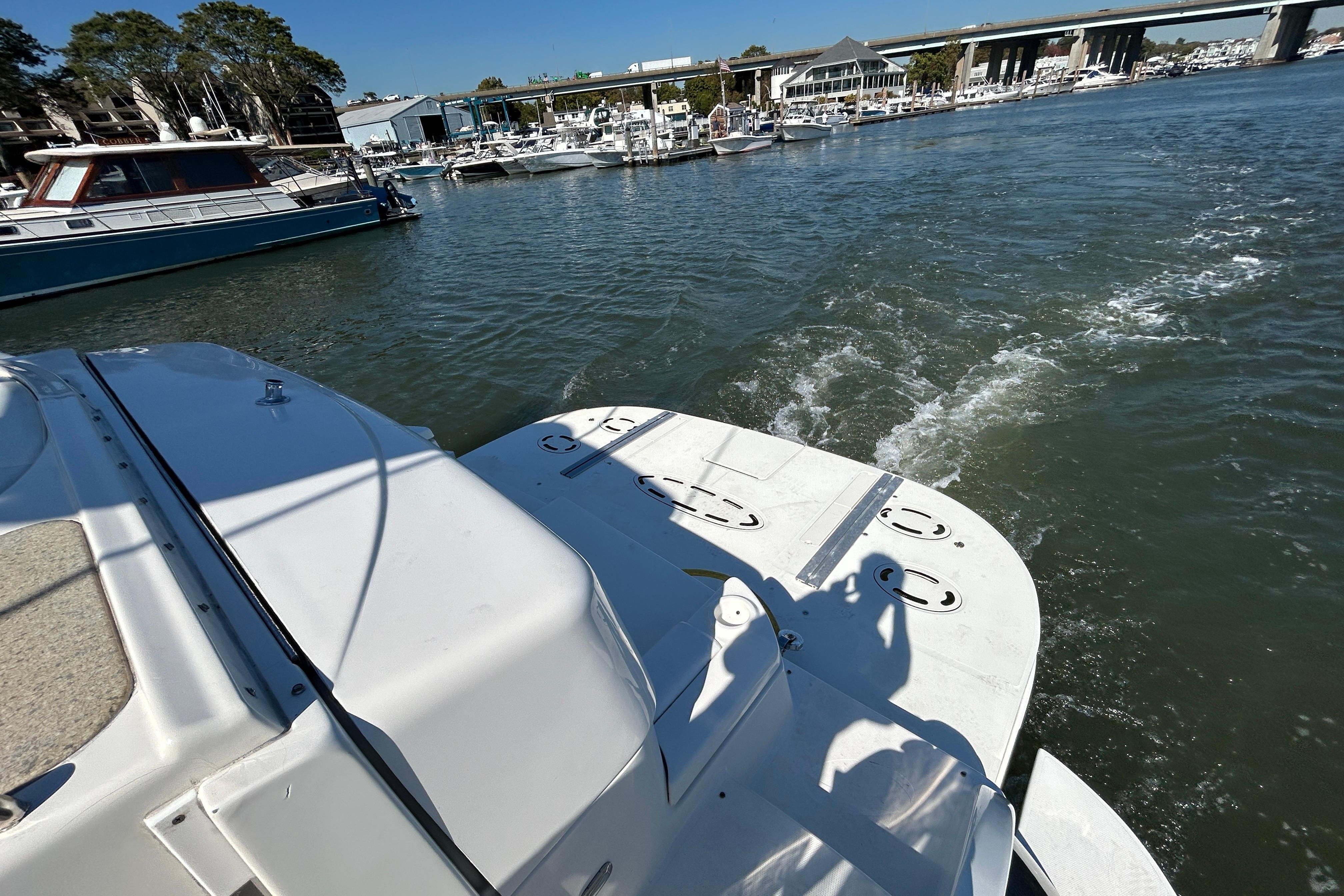 2003 Cruisers Yachts 540 Express on water near marina, sunny day.