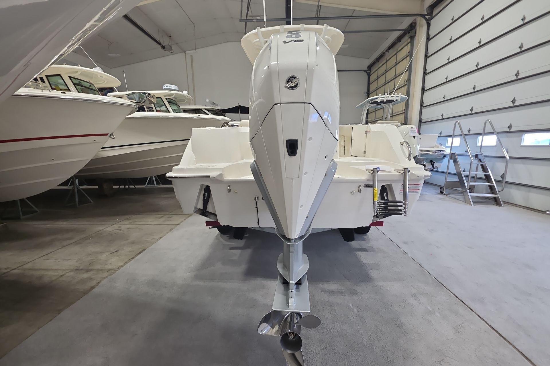 2026 Boston Whaler 230 Outrage boat in indoor storage, rear view.