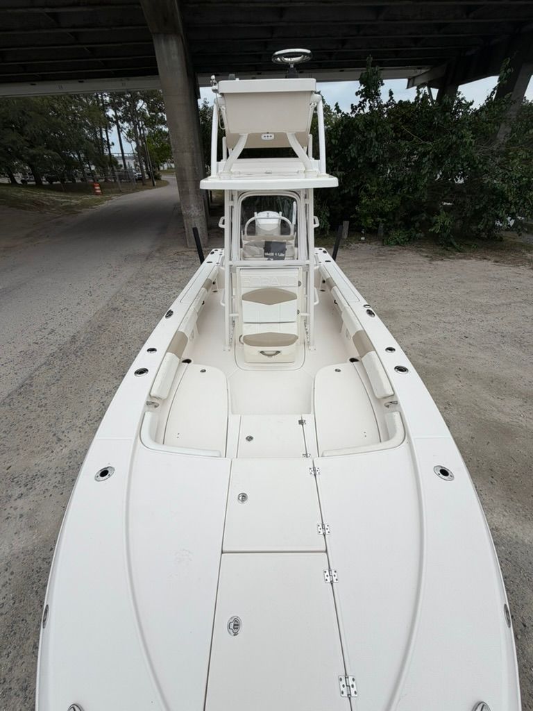 2018 Robalo 246 Cayman SD boat parked under a bridge.