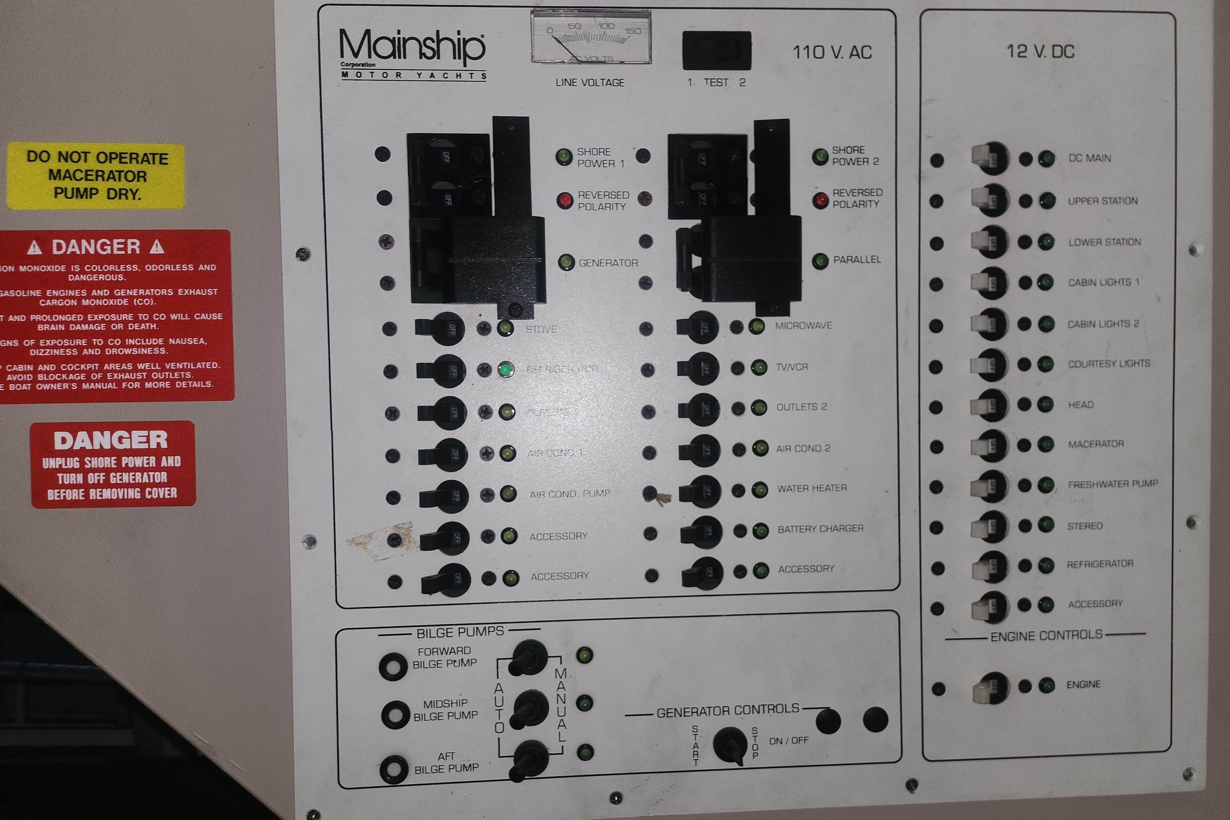 Electrical panel of a 1997 Mainship 350 Trawler with safety warnings and controls.