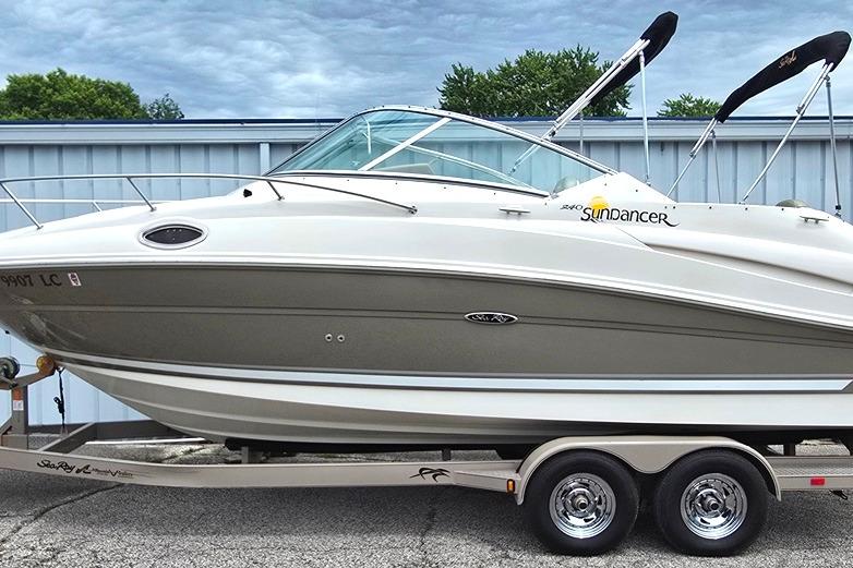 2006 Sea Ray 240 Sundancer boat on trailer, parked outdoors.